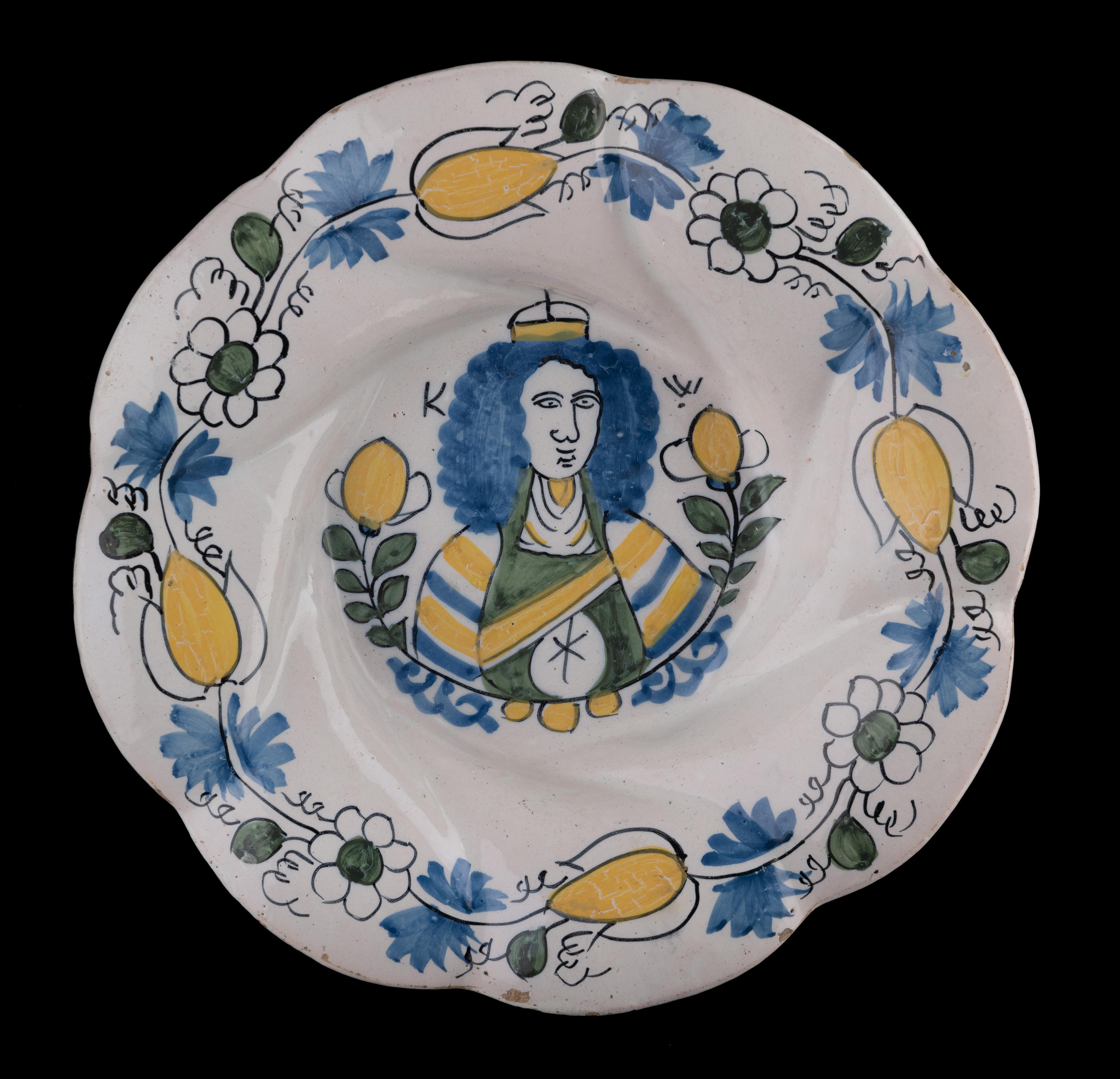 Polychrome lobed dish with King William III
Delft, circa 1690

The polychrome lobed dish is composed of eight wide and twisted lobes and is painted in blue, green and yellow with a depiction of King-Stadholder William III between two flowering