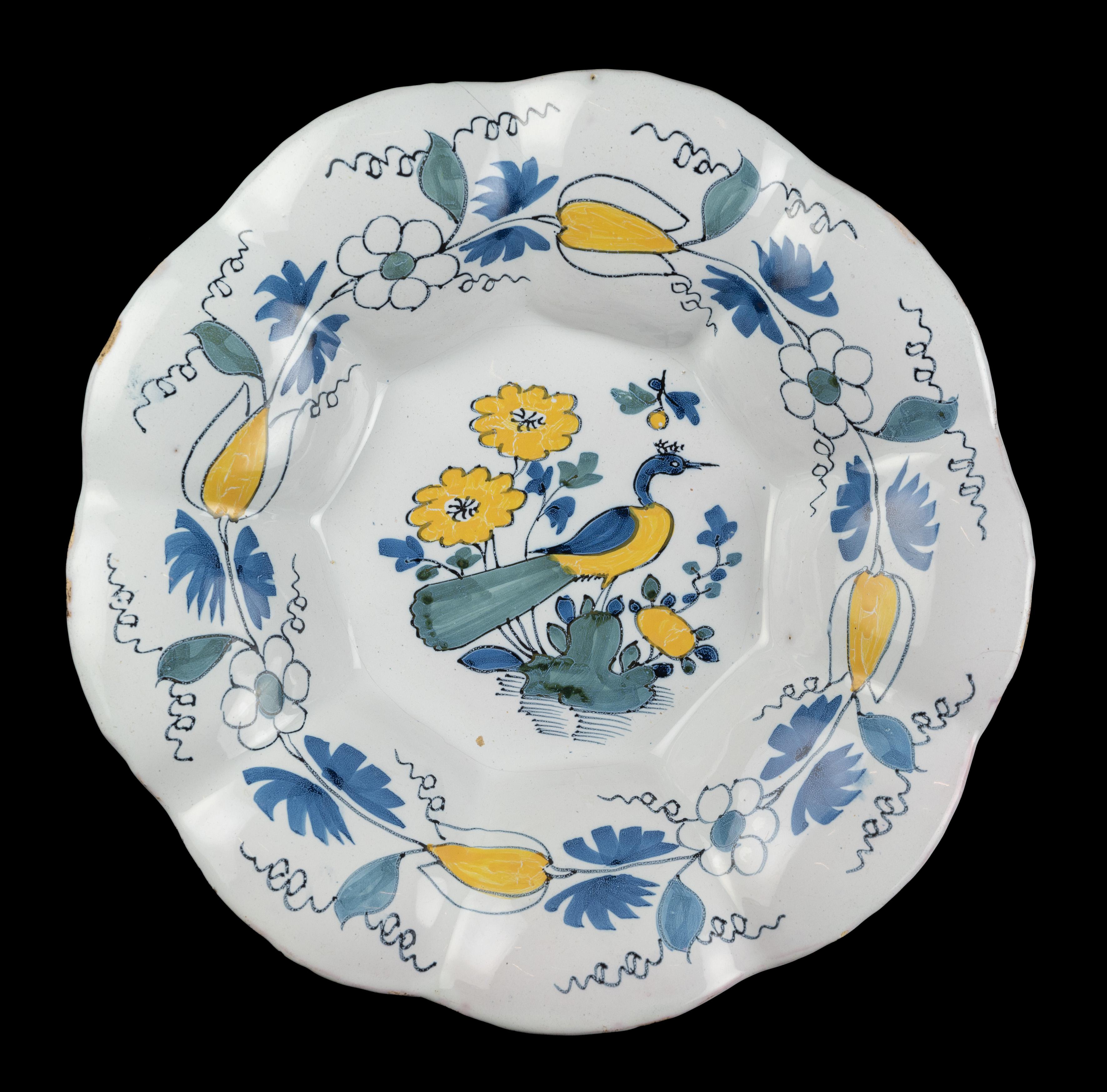 Polychrome lobed dish with peacock. Delft, circa 1680 
Dimensions: diameter 34,7 cm / 13.66 in.

The polychrome lobed dish is composed of nine wide lobes and is painted in the centre with a peacock on a rock in water overgrown with flowers and