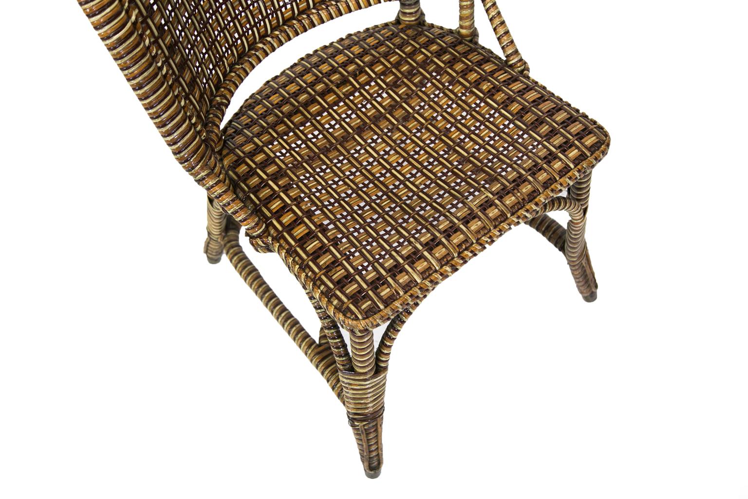 Polychrome rattan side chair has a signed copper plaque, “Aster Registered”. There are angled seat braces and curved arched leg supports with a crinoline style stretcher. The back is framed with split bamboo on the back side and spiral rolled rattan