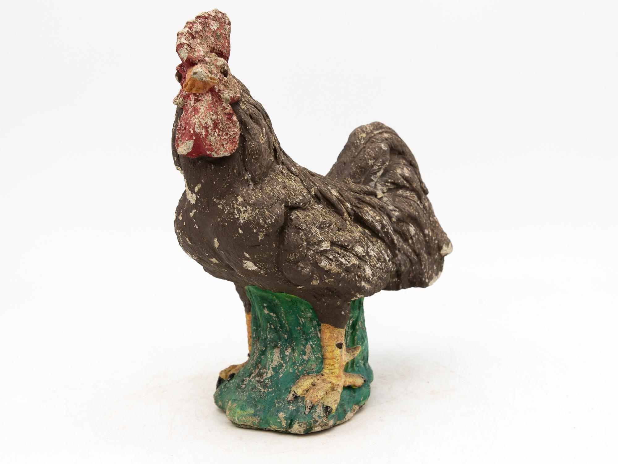Diese ikonische Skulptur eines französischen Landhahns aus gealtertem Beton strahlt rustikale Eleganz und zeitlosen Charme aus. Es hat viel von seiner ursprünglichen roten, braunen, gelben und grünen Farbe behalten und weist eine ehrliche Alters-