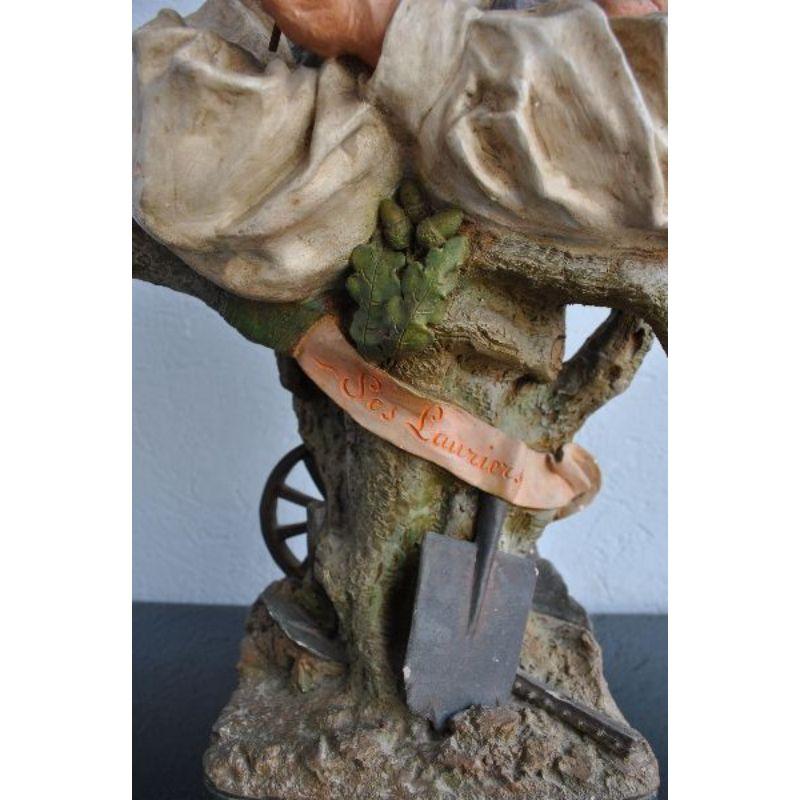 Polychrome terracotta signed Joseph Le Guluche (1849-1915) French sculptor (1849-1915) representing an old plowman with the inscription laurels on a ribbon. Good general condition dimension height 64 cm for a width of 32 cm and a depth of 22