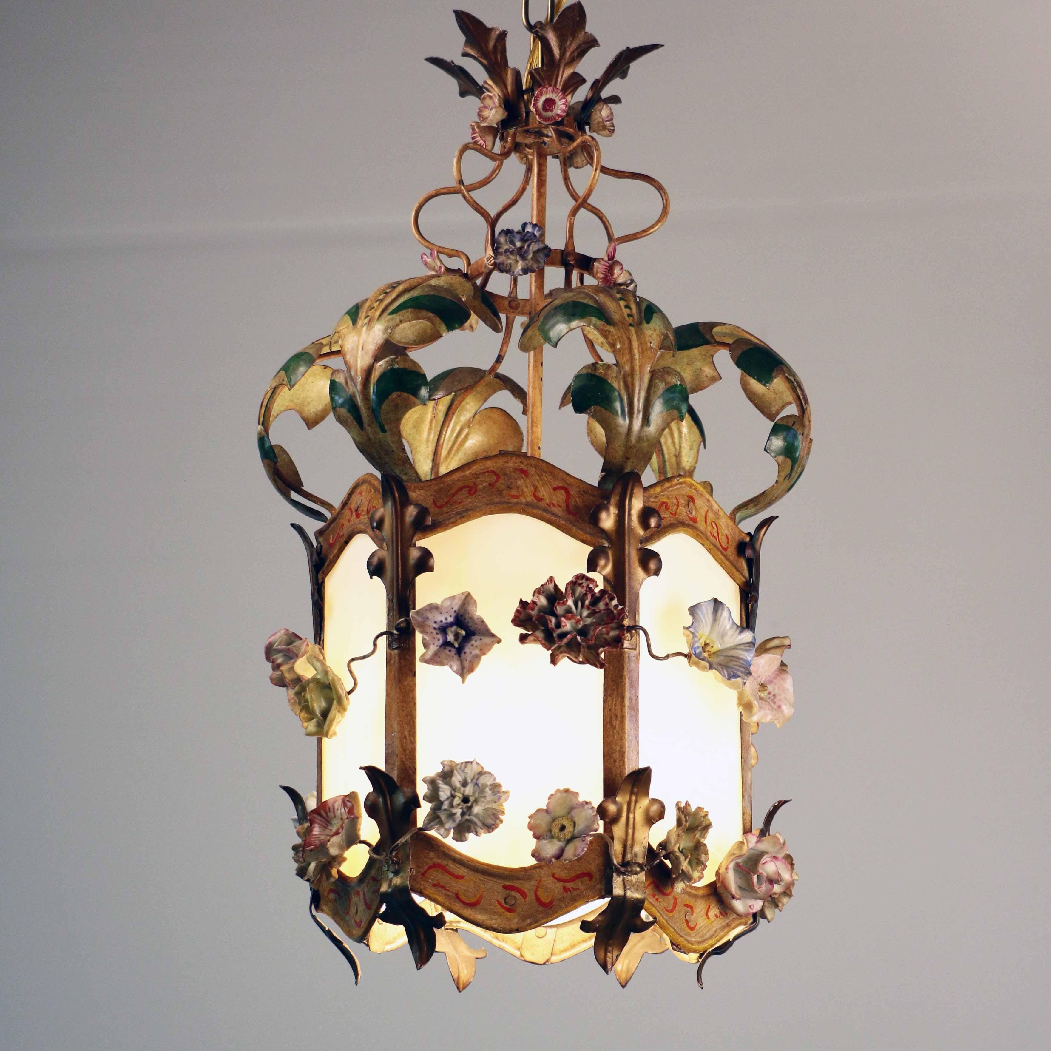 This charming whimsical French lantern interprets playfully the Louis XV style, retaining its essence while abandoning formality. The hexagon frame and ornamental acanthus and leaves are artfully constructed in tole and then painted, the polychrome