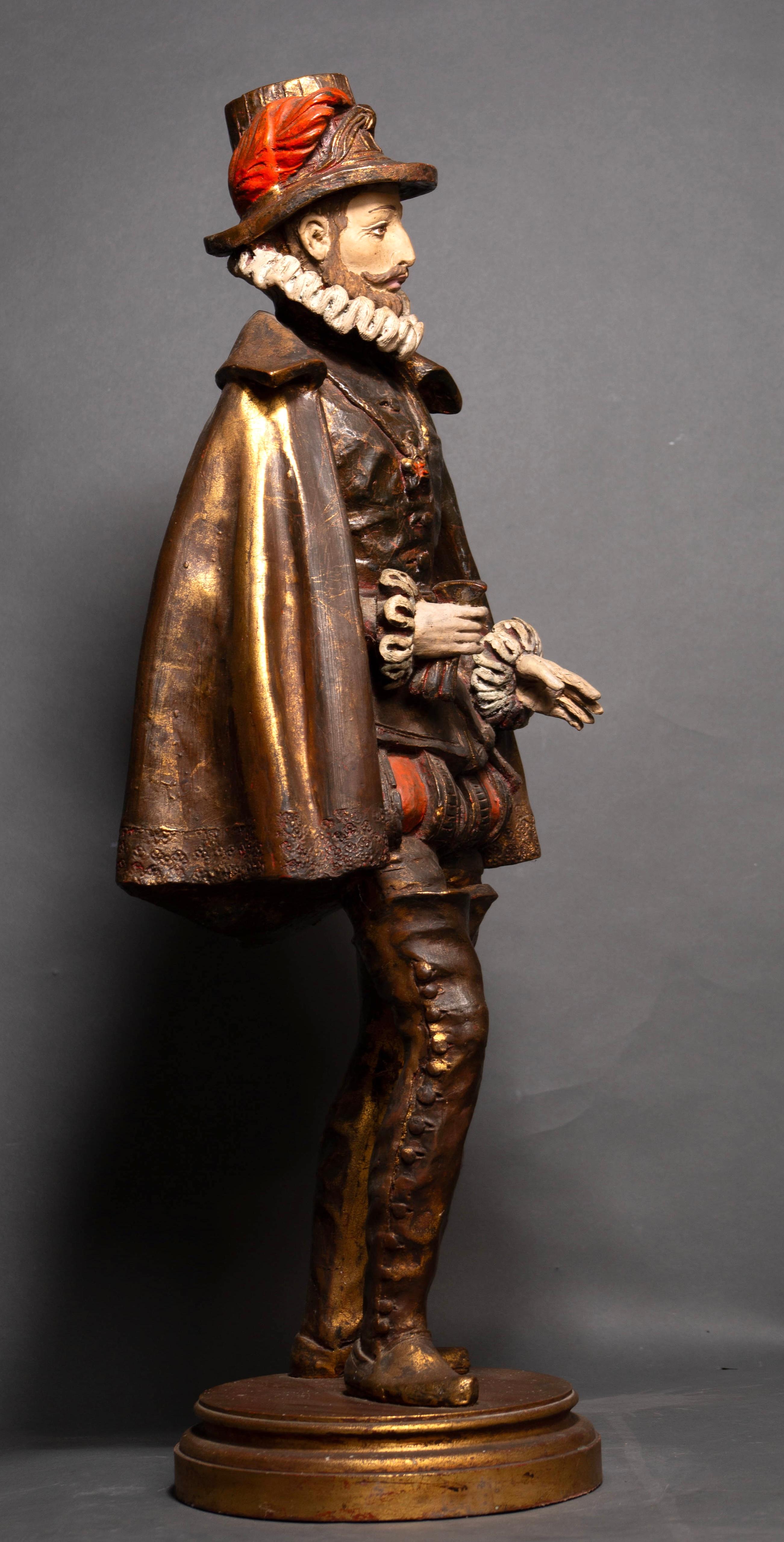 Questa imponente statua in legno policromo del XIX secolo incarna l'eleganza e la grandezza del Rinascimento francese, evocando lo splendore cortese di Francesco I e la vivacità teatrale della Commedia dell'Arte. Con un'altezza imponente di 86 cm,