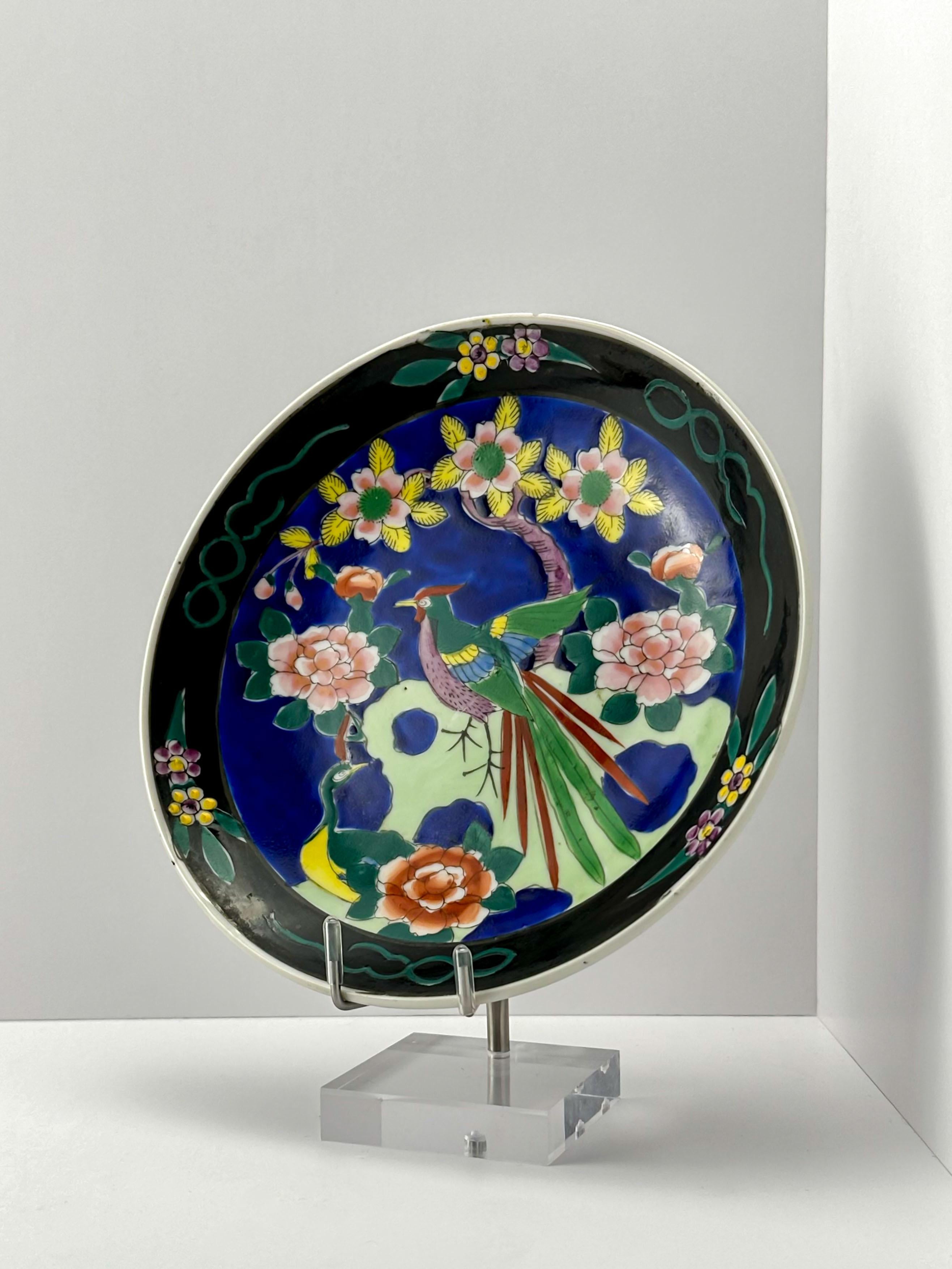 Piatto da portata giapponese in stile Chinoiserie, nero e policromato, realizzato a mano negli anni '40 da Dai Nippon.

Smaltato a mano con una colorata scena figurata giapponese, raffigura stilisticamente fiori di ciliegio e peonie in fiore,