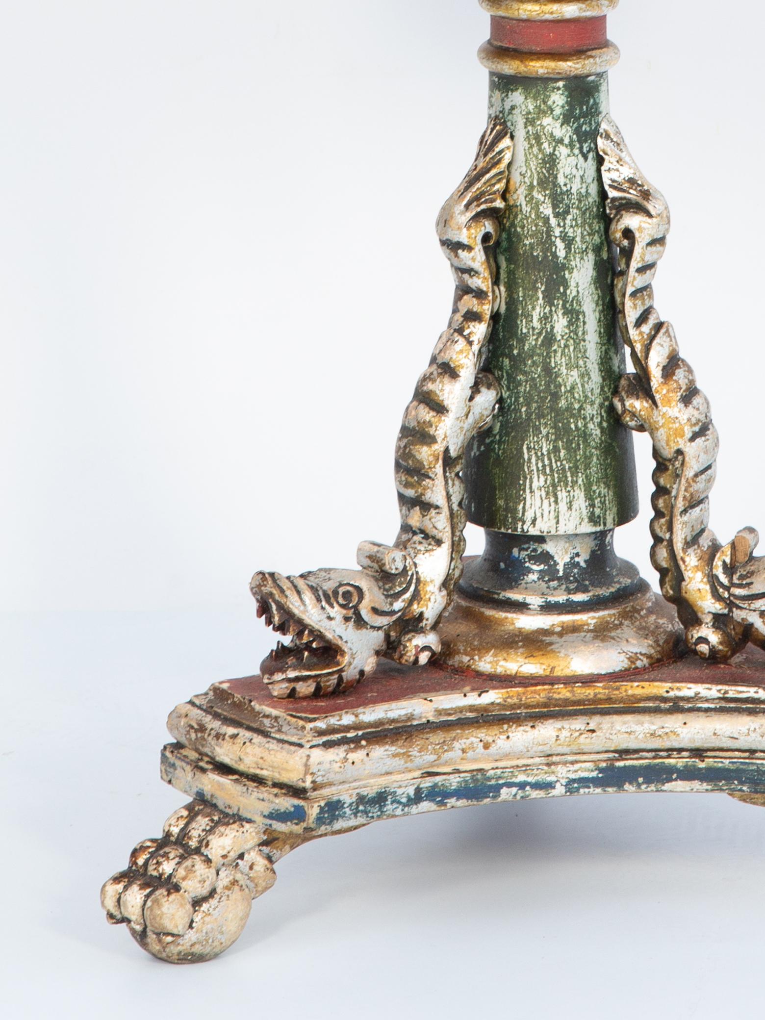 Table d'appoint à finition polychrome présentant une usure naturelle, à plateau rond en marbre rouge avec tablier en tole repoussée, à base de colonne à piédestal en forme de bouton flanquée d'un trio de dauphins en vermeil sculptés à la main, sur
