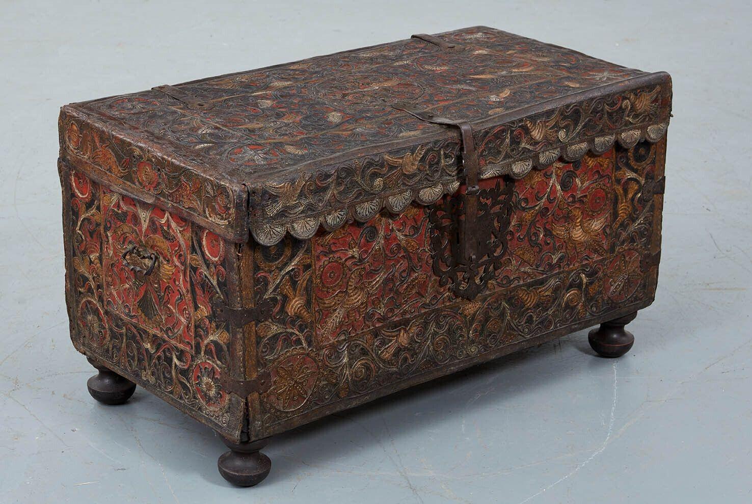 An early leather trunk decorated with complex rillette embossing and retaining elements of its original polychromed decoration. Hand-forged hinges, corner straps and a fabulous central lockplate under scalloped front edge, Standing on later bun