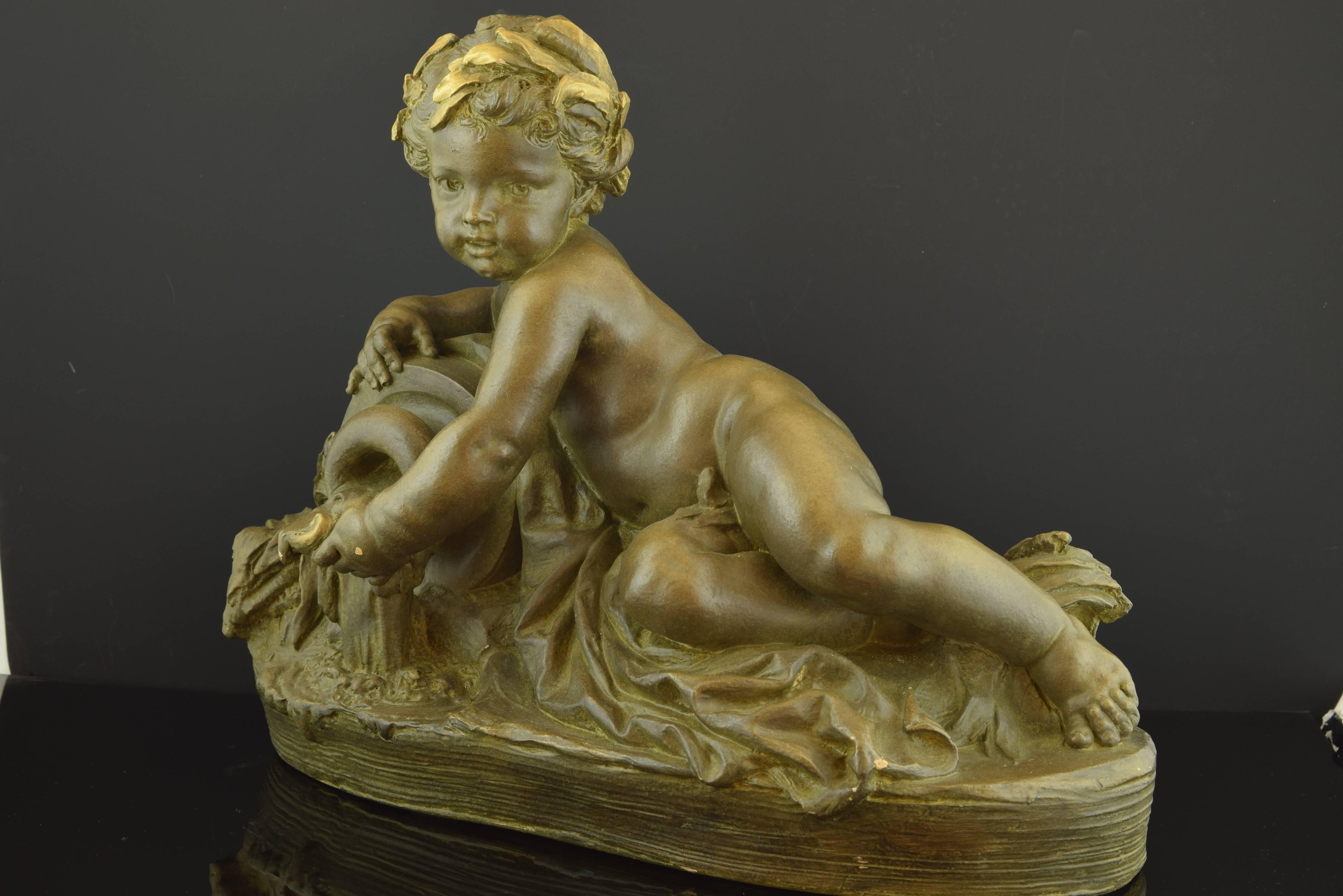 The fountain. Polychrome terracotta. 20th century, following models of CARRIER-BELLEUSE, AlbertErnest (Aisne, 1824-Sèvres, 1887). 
The figure shows a boy, lying down and almost totally naked, with his head enhanced by a golden leaf crown. It is