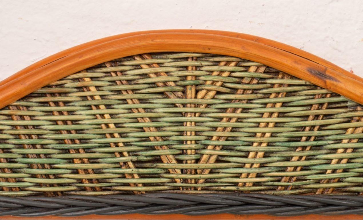 Rustic polychromed wicker framed mirror, rectangular and centering a mirror plate, the exterior wicker border painted green and black, the exterior rattan in natural hue. 

Dealer: S138XX