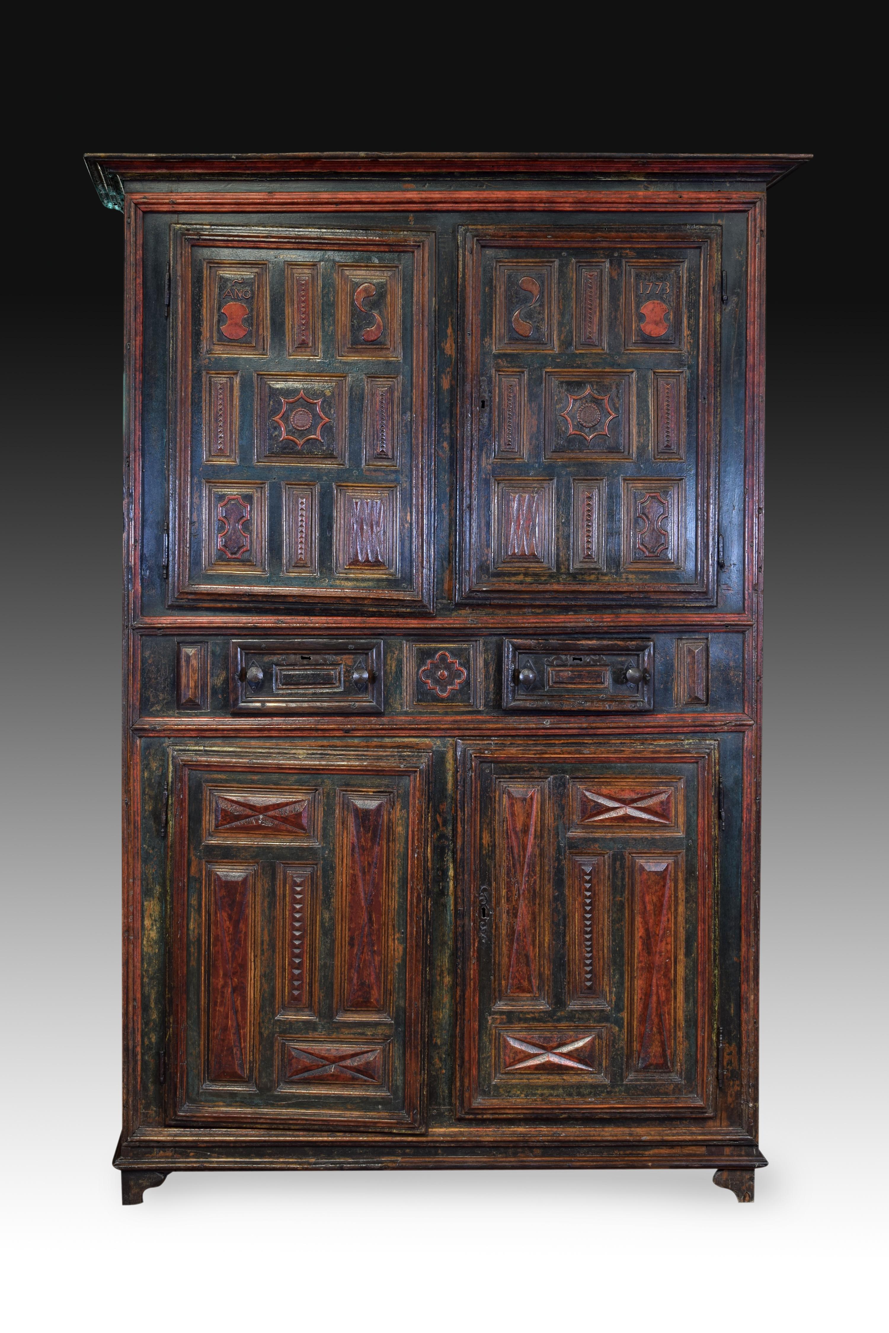 Polychrome closet. Carved wood, polychrome, iron. 18th century (1773). 
High cabinet with four doors and two drawers made of carved and polychrome wood decorated to the outside with a series of moldings and flat carvings organized in square and