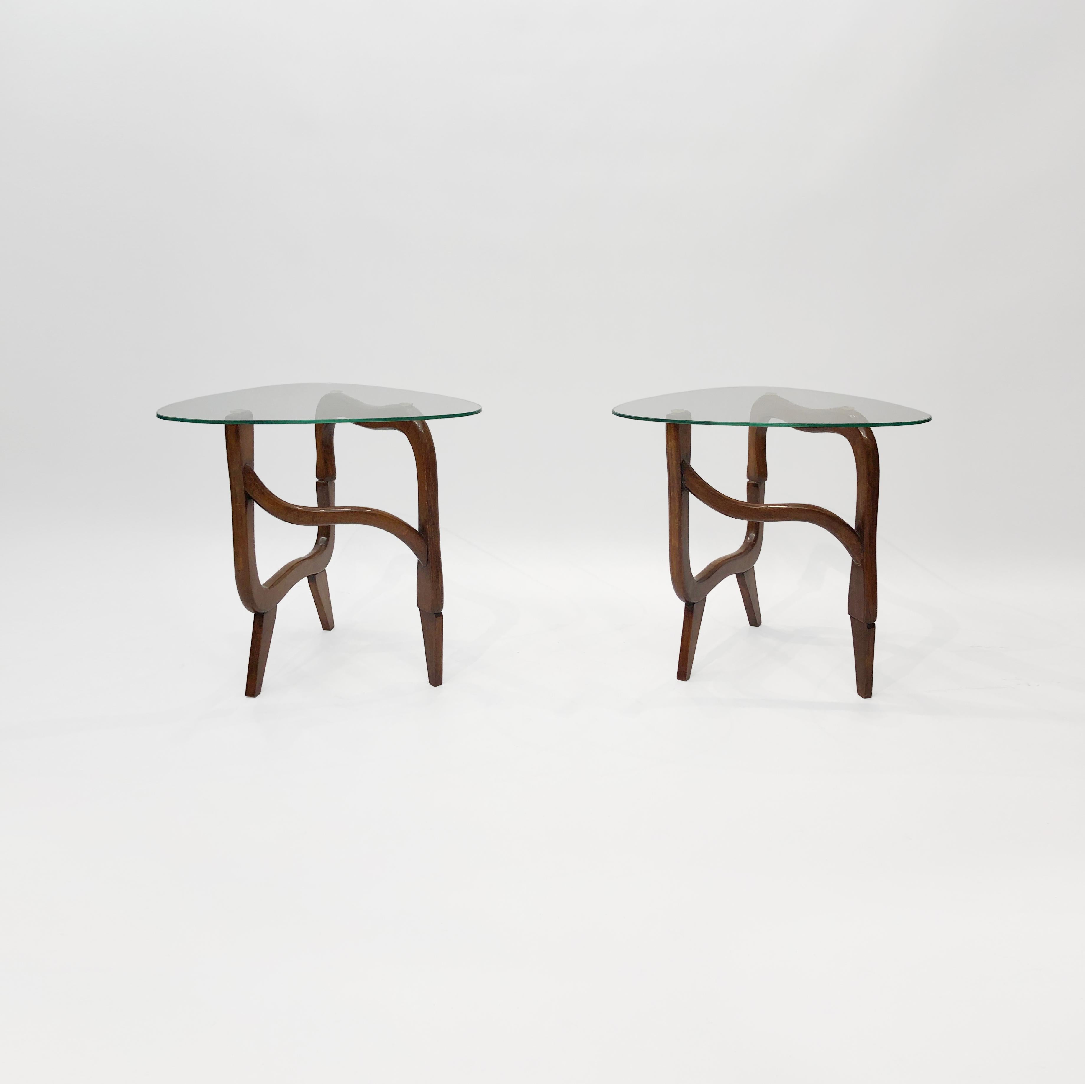 An interesting pair of teak side tables with organic twisting bases and triangular glass tops, particularly reminiscent of the Isamu Noguchi’s eponymous Classic coffee table of the 1947. The delicate yet durable form of the polymorphic teak base is