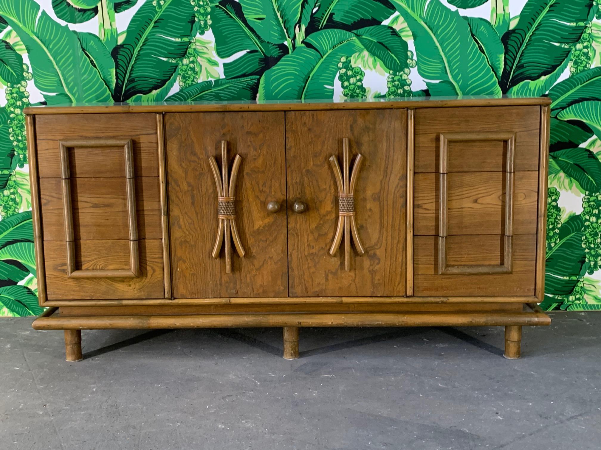 Vintage tiki-style dresser features solid wood construction and rattan detailing in true Polynesian style, circa 1960s. Good vintage condition with imperfections consistent with age.