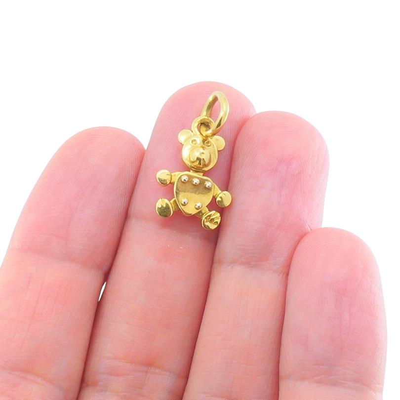 Estroso ed elegante, questo ciondolo a forma di orsetto di Pomellato è realizzato in oro giallo 18 carati. Il design giocoso è caratterizzato da una testa arrotondata, arti articolati e un busto arricchito da borchie dorate in rilievo, per mostrare