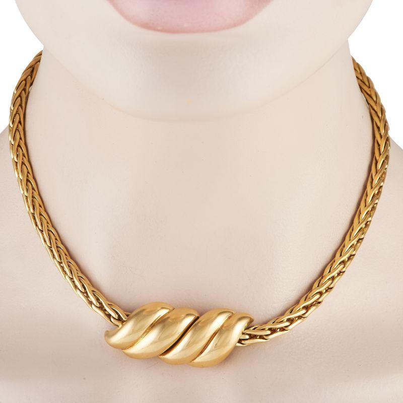 A vintage Pomellato piece perfect for bringing personality to basic outfits. It features a woven-style chain of 18K yellow gold swirling links holding a 1.85