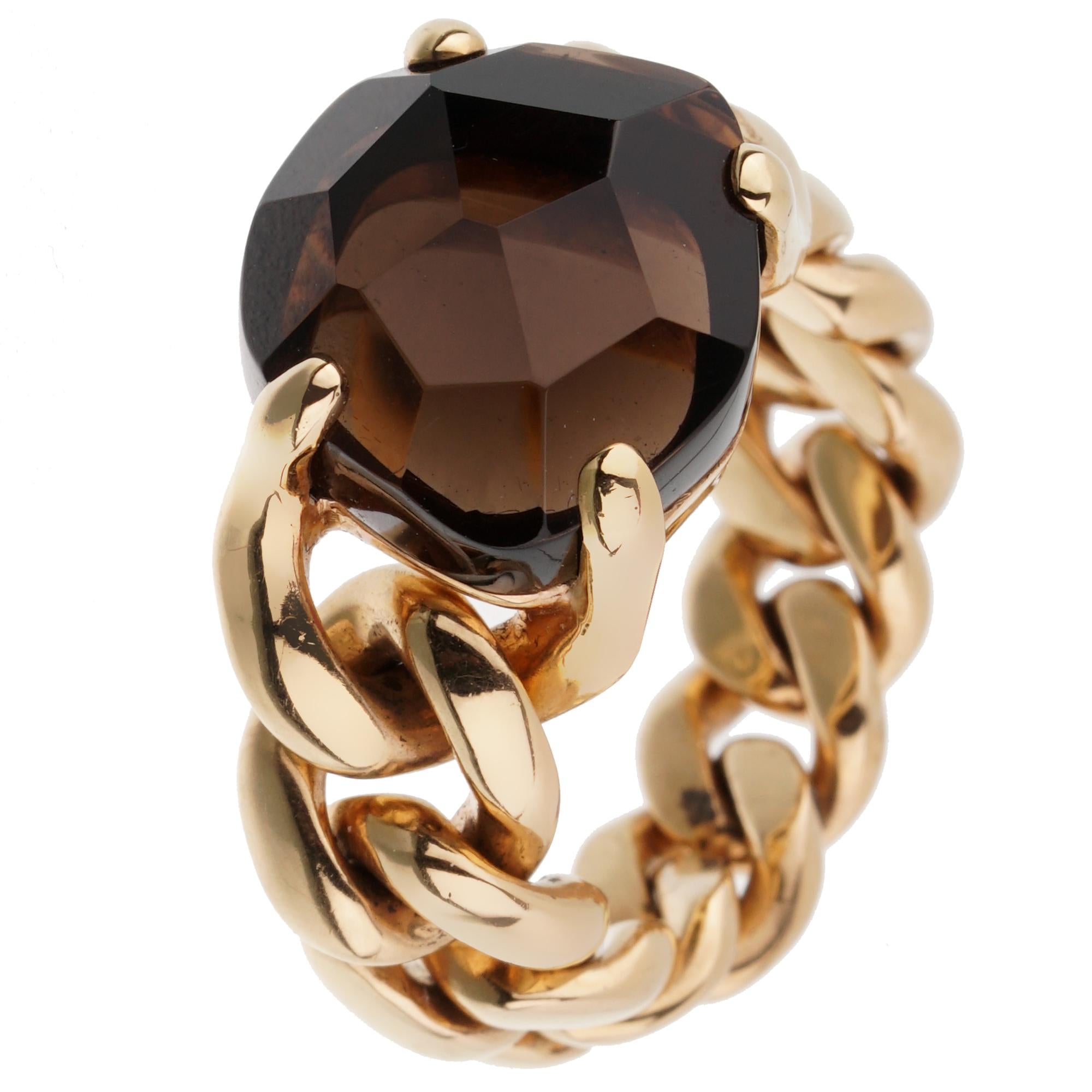 A timeless Pomellato chain link cocktail ring showcasing a 6.65ct smoky quartz prong set in shimmering 18k yellow gold. The ring measures a size 7