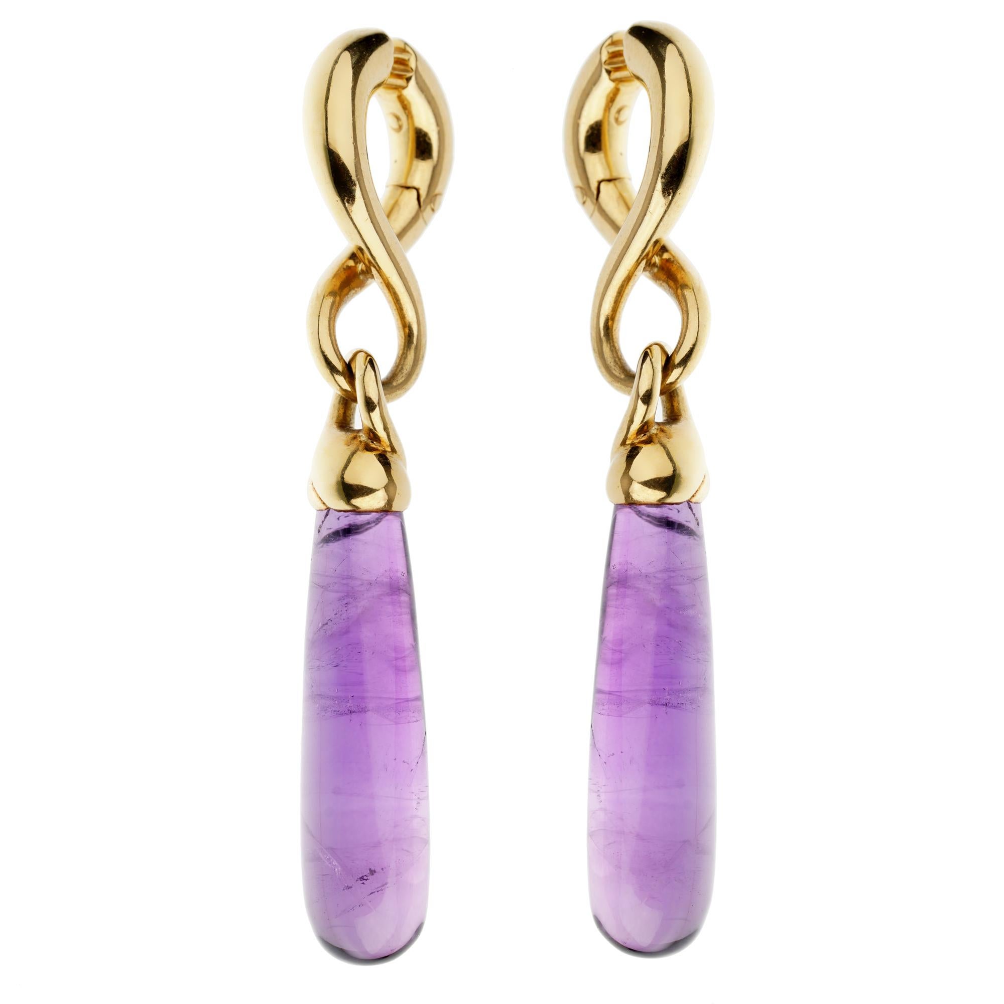 An unmistakable pair of Pomellato earrings showcasing 2 large amethysts suspended by an 18k yellow gold figure 8 motif. The earrings measure 2 1/2