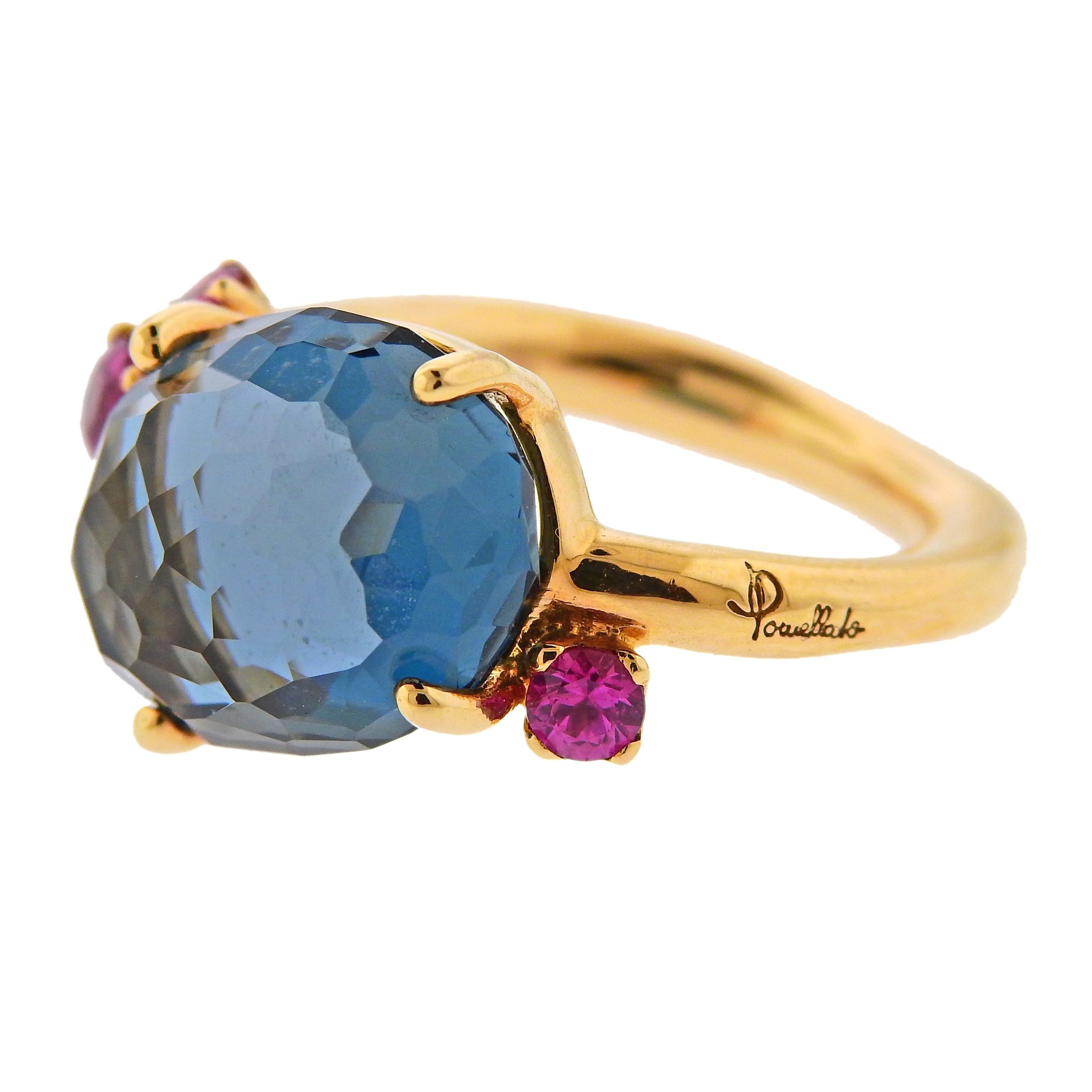 18k gold ring crafted by Pomellato for the Bahia collection. Features London blue topaz center stone and rubies. Ring size -6, ring top - 13mm x 19mm. Weight 8.9 grams. Marked: Pomellato, 750, Serial number. 