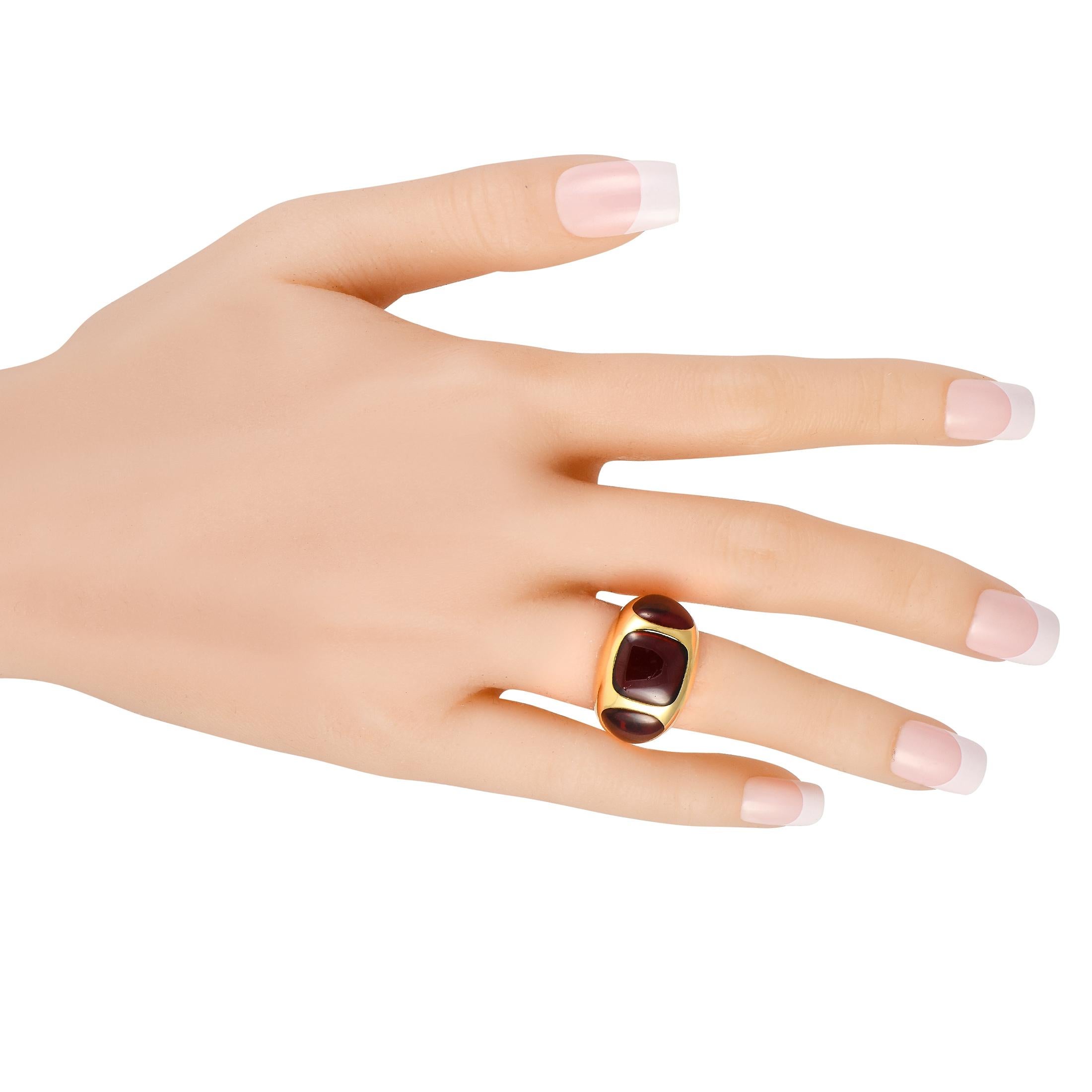 A chunky ring from Pomellato's Bisanzio Collection. This eye-catching cocktail ring features a domed band in 18K yellow gold. Three garnet cabochons in closed settings punctuate the widest part of the shank. The ring's top dimensions measure 17mm x