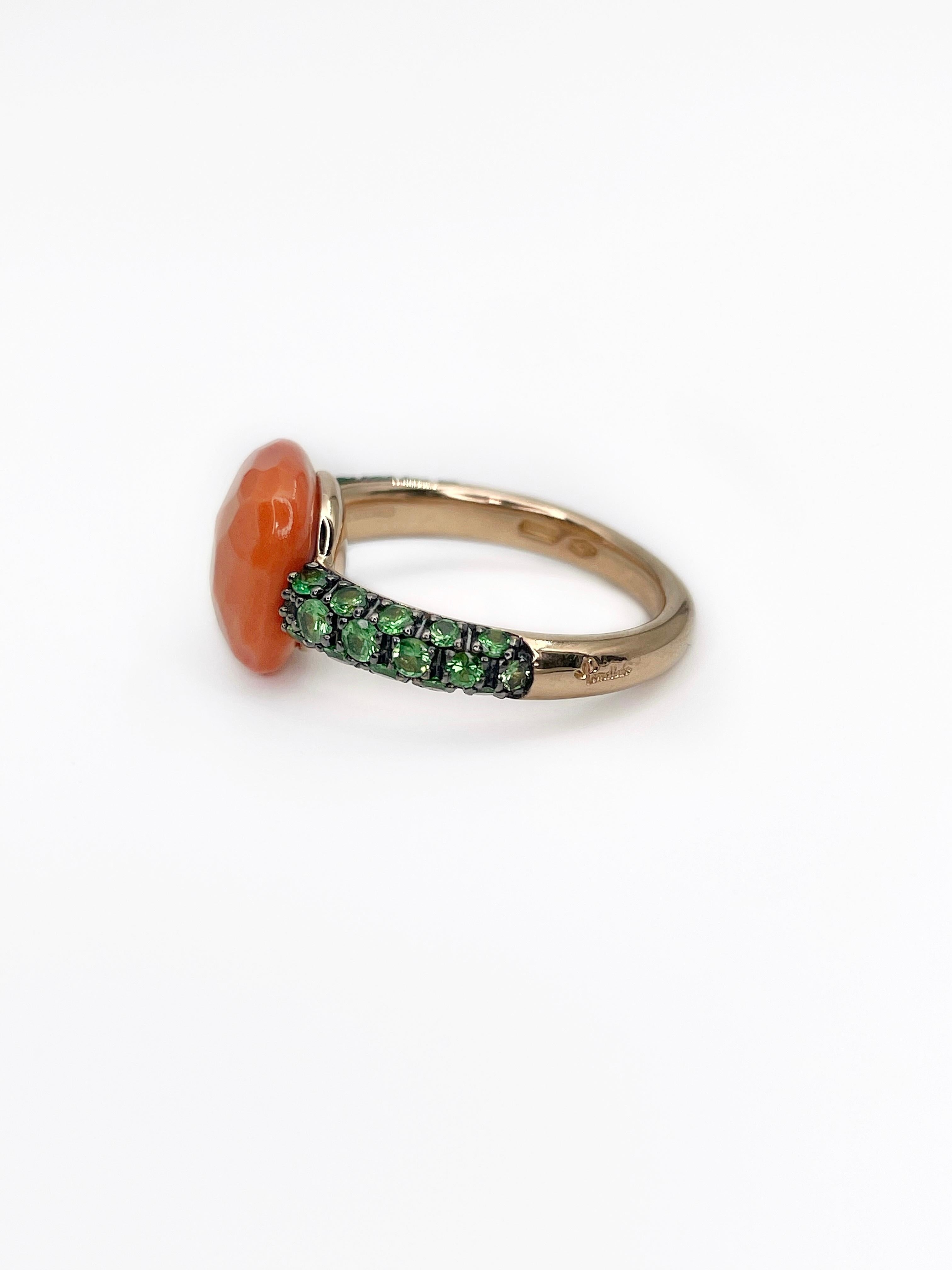 Pomellato cocktail ring features square faceted coral (1.1x1.1cm). It is embellished with 30 round green tsavorite garnets set in 18K gold. 

Pomellato “Capri” collection is inspired by the vivid colours of the Mediterranean and sunny island’s hues.