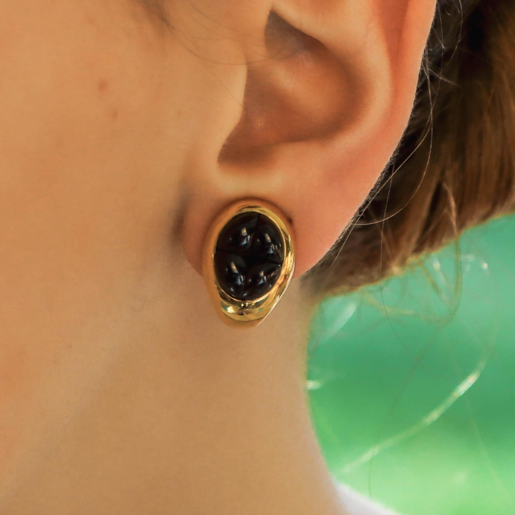 A rather interesting pair of Pomellato deep red cabochon garnet clip-on earrings set in 18k yellow gold. 

Each earring is composed of four beautifully carved cabochon garnet stones which perfectly slot next to one another to give the illusion of