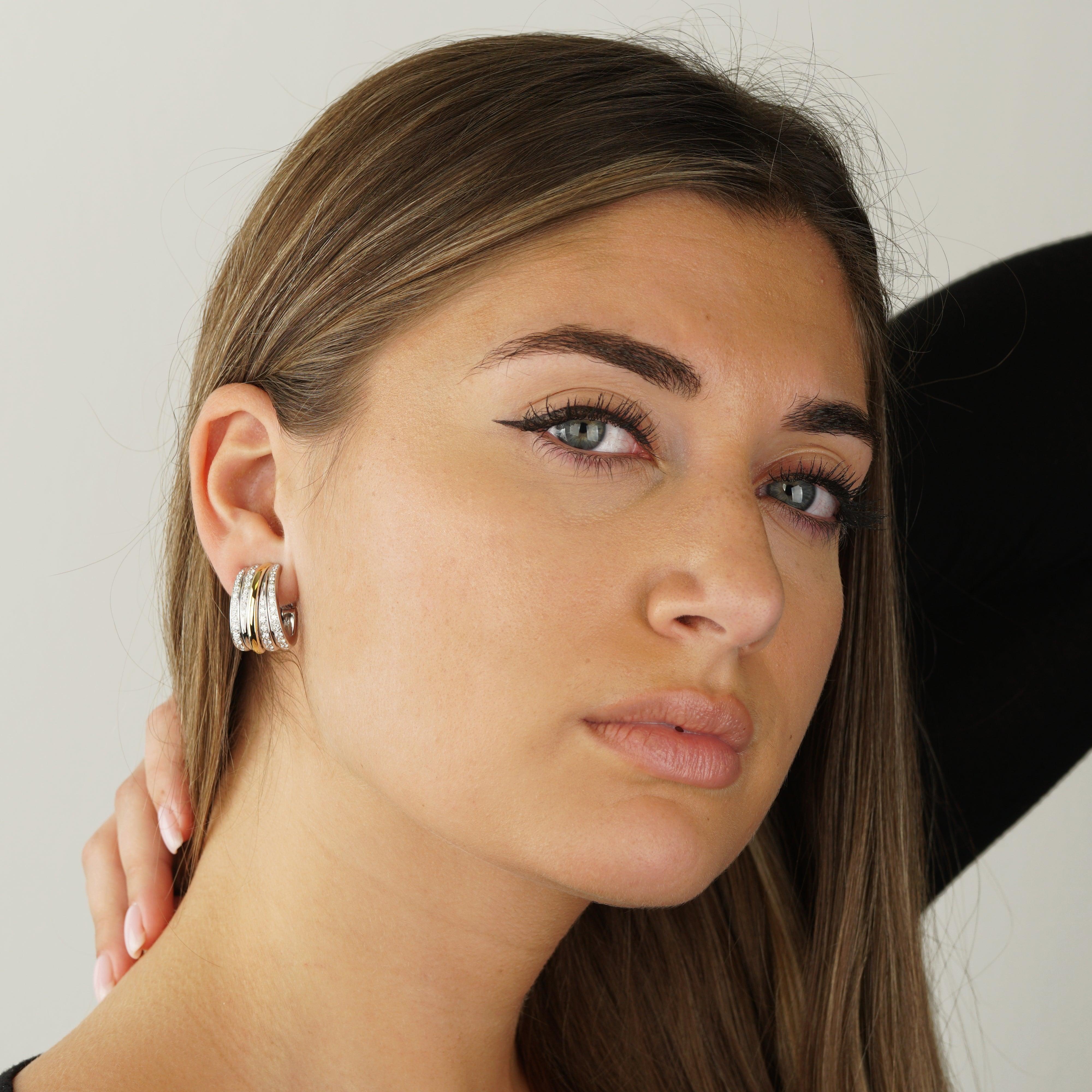 Gli orecchini a cerchio con diamanti Pomellato fondono un'eleganza senza tempo con un tocco moderno in un design in oro bicolore. Realizzati in oro bianco 18 carati e accentati da una barra diagonale in ricco oro rosa, presentano 1,35 carati di