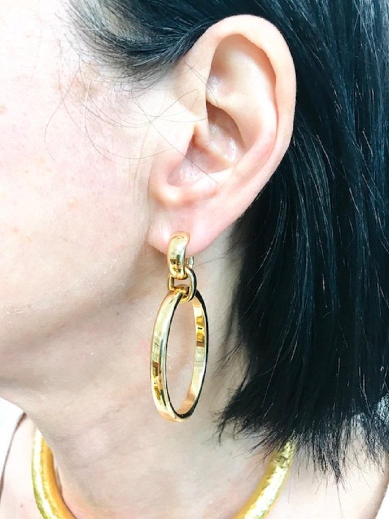 A pair of glossy 18k gold earrings by Pomellato.  Designed as large oval dangling hoops, the earrings hang beautifully on an ear. Polished gold with satin finish adds a glamorous touch to the earrings' look. These Pomellato earrings are a great pair