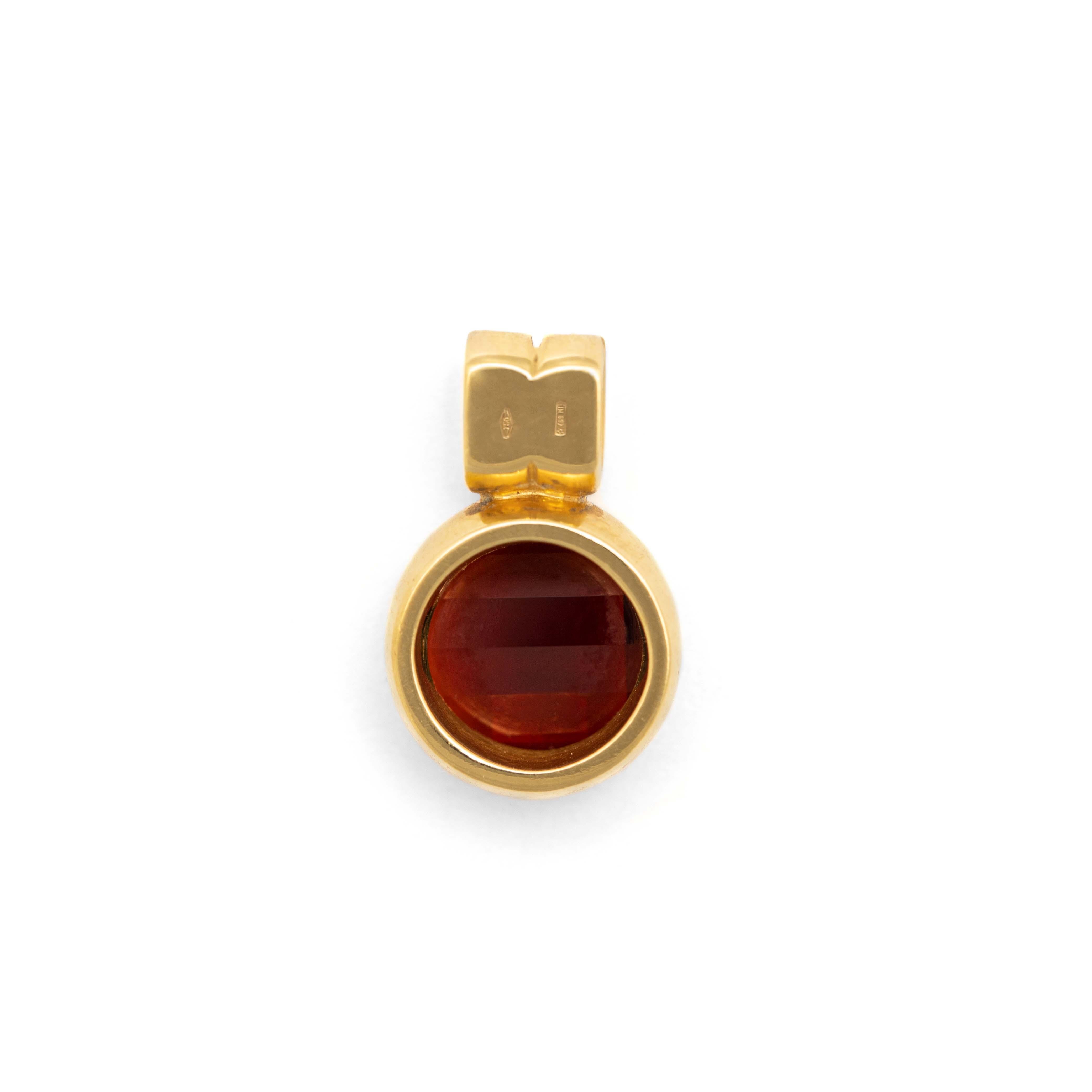 Round Cut Pomellato. Gold pendant holding a faceted garnet set with round-cut diamonds.