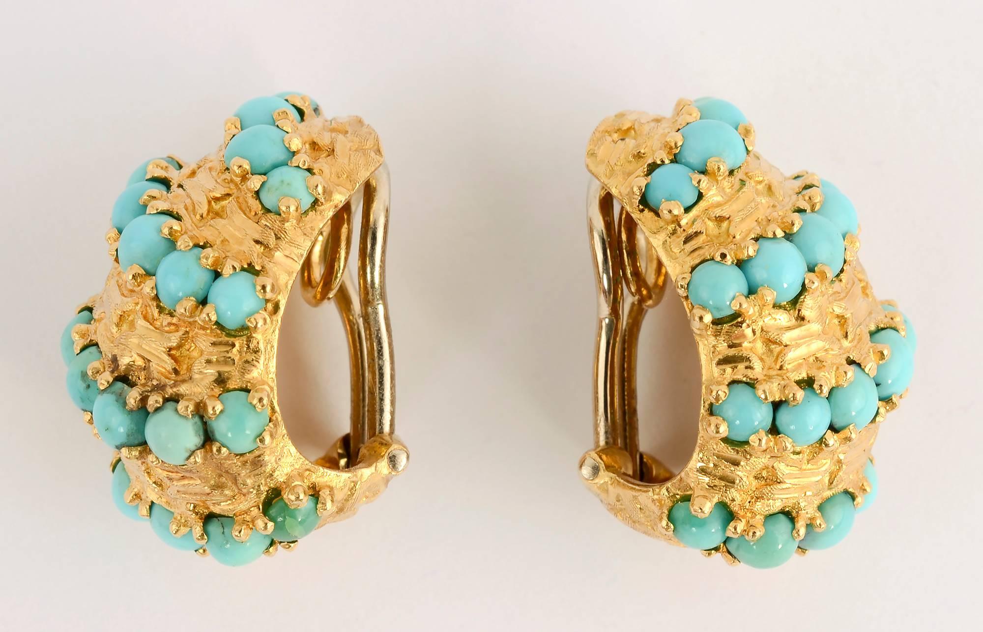 Wonderfully textured half hoop earrings by Pomellato. The swirls of gold are echoed by rows of richly colored oval turquoise stones. The earrings measure 7/8