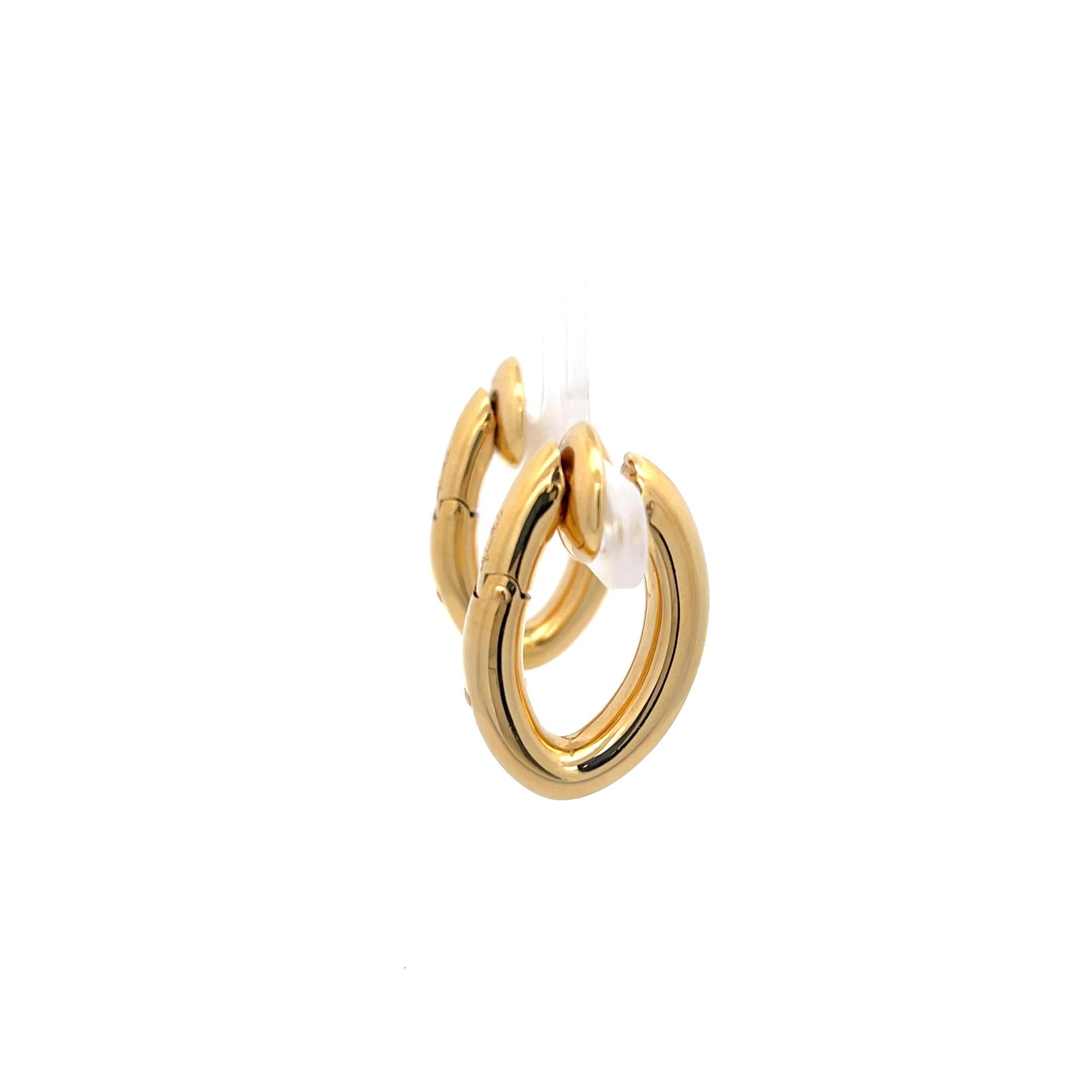 Cerchi di Pomellato in oro giallo 18 carati. Orecchini a clip senza perno. I cerchi hanno una dimensione di 1 pollice per 3/4, una larghezza di 5,35 mm e un peso di 22 grammi. 