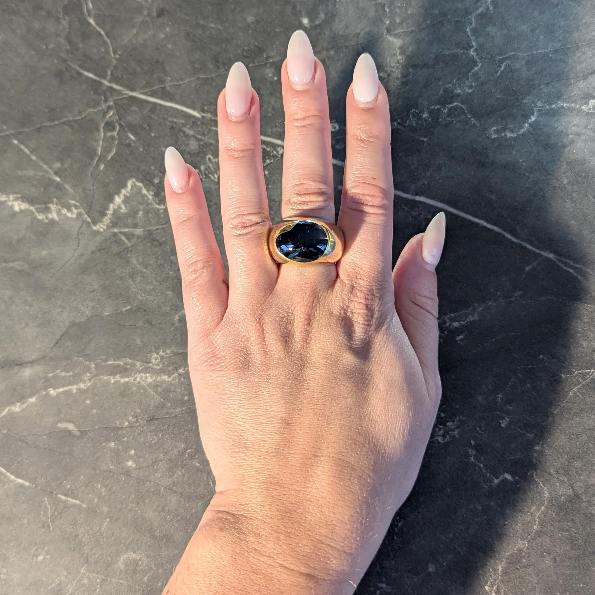 Designed as a domed wide gold ban centering a flush set cabochon
Flush set as kidney bean shaped topaz - measuring 15.0 x 18.0 mm
Translucent dark 