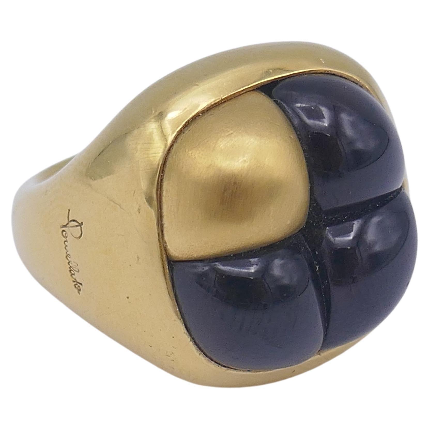 An 18k gold Pomellato garnet ring, from Mosaïco collection.
The dome part has four squar'ish sections. Three sections are garnet and one is gold. The garnet looks almost black and is glowing red while looking from the angle.  It's a unique,