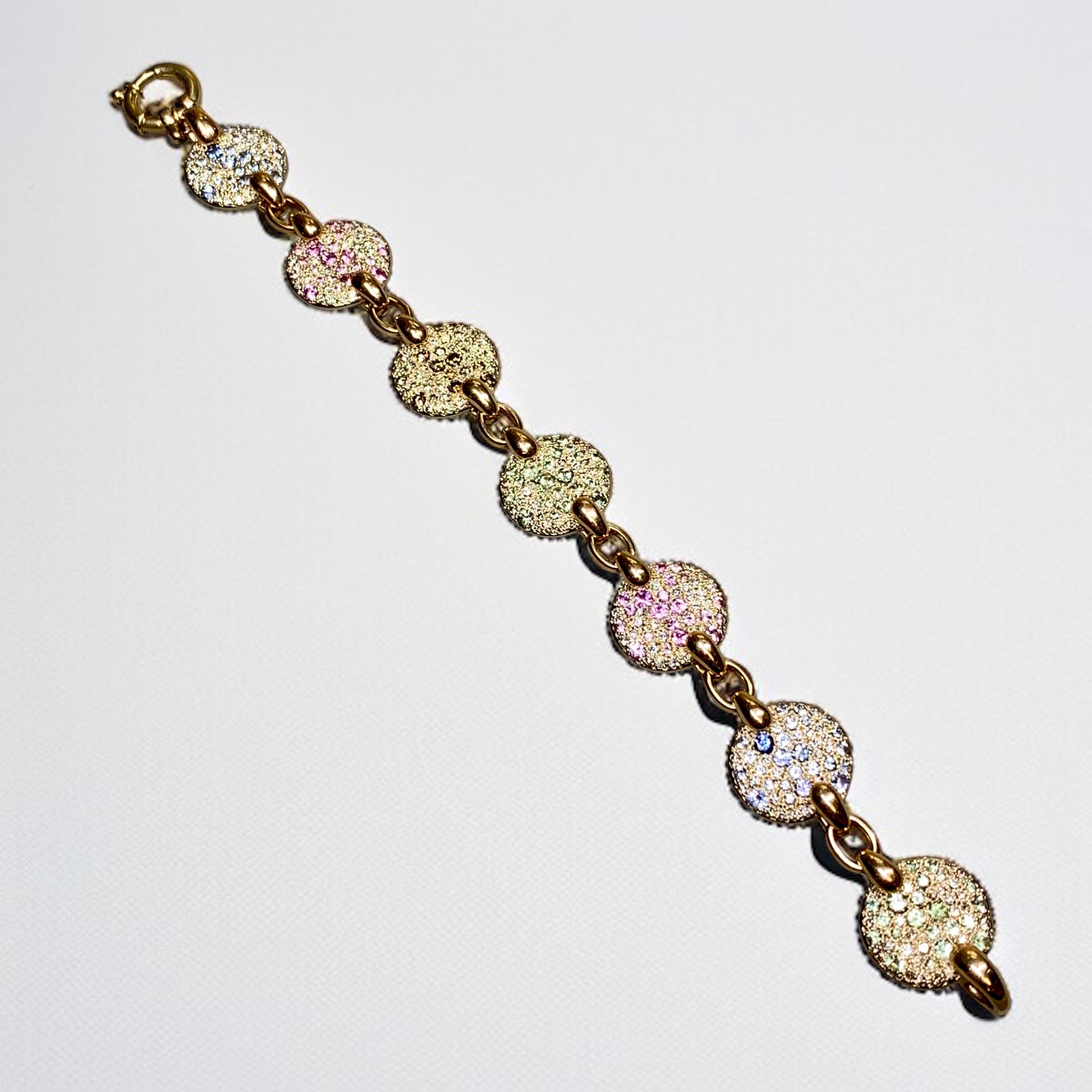 The original Sabbia bracelet (now discontinued) by Italian jewelry house, Pomellato. It is hand crafted in 18K rose gold and set with approximately 10.50ctw in natural pink, blue and green sapphires as well as brown and white diamonds. Stamped 489MI