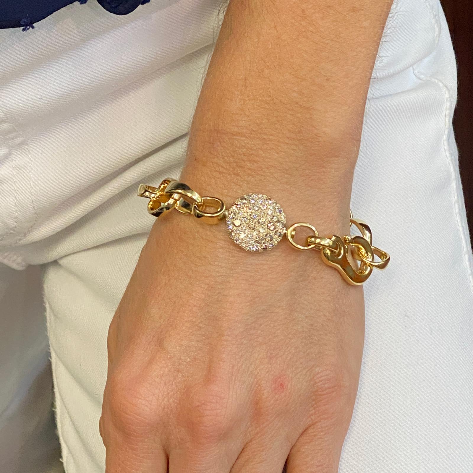 Stylish diamond link bracelet by Italian designer Pomellato fashioned in 18 karat yellow gold. The open link bracelet this S hook closure features round brilliant cut white and champagne diamonds weighing approximately 1.89 carat total weight. The