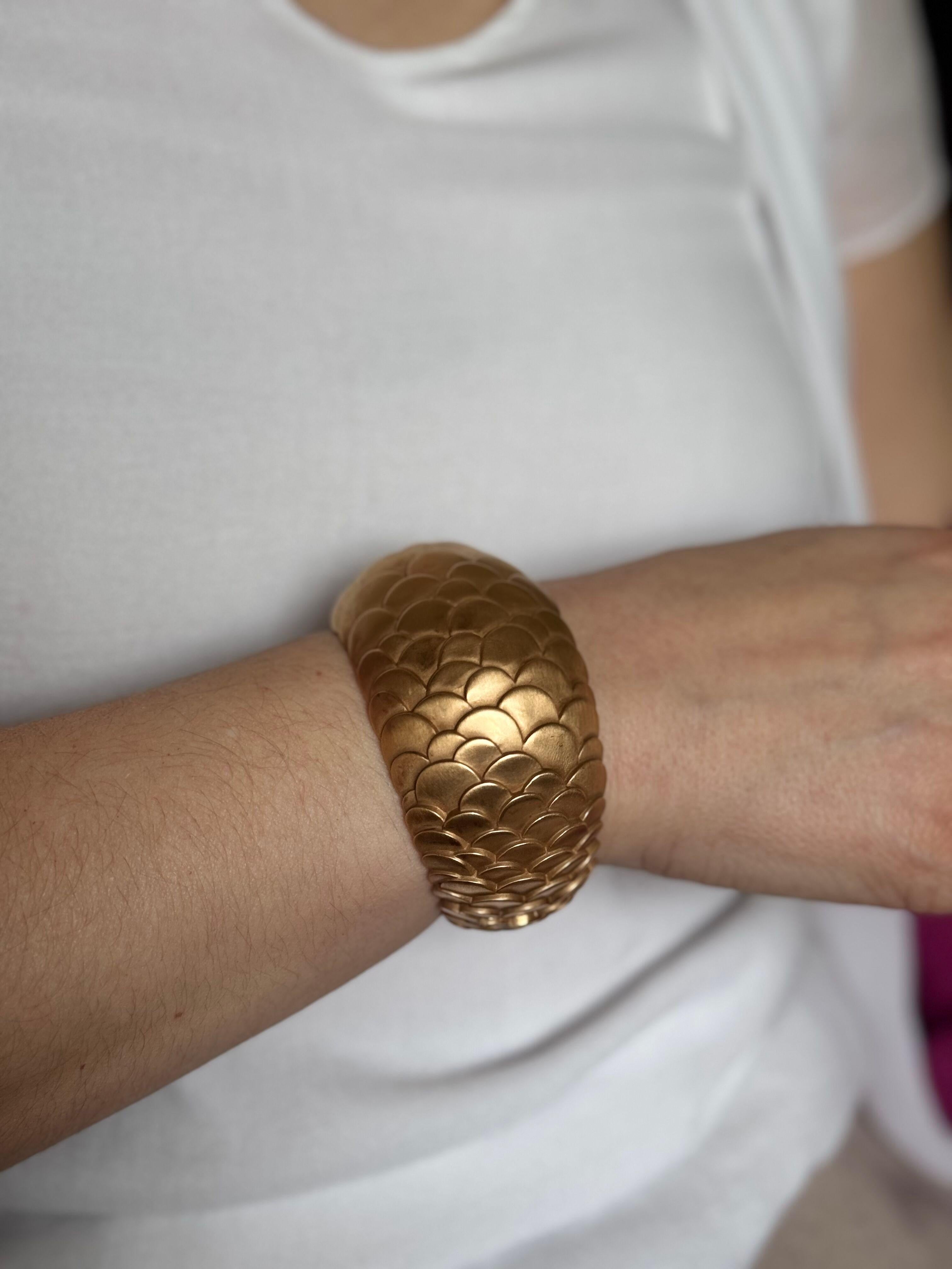Bracelet en or rose 18k mat de Pomellato de la collection Sirenes, présentant un motif d'écailles de poisson.
Le bracelet s'adapte confortablement à un poignet d'environ 7