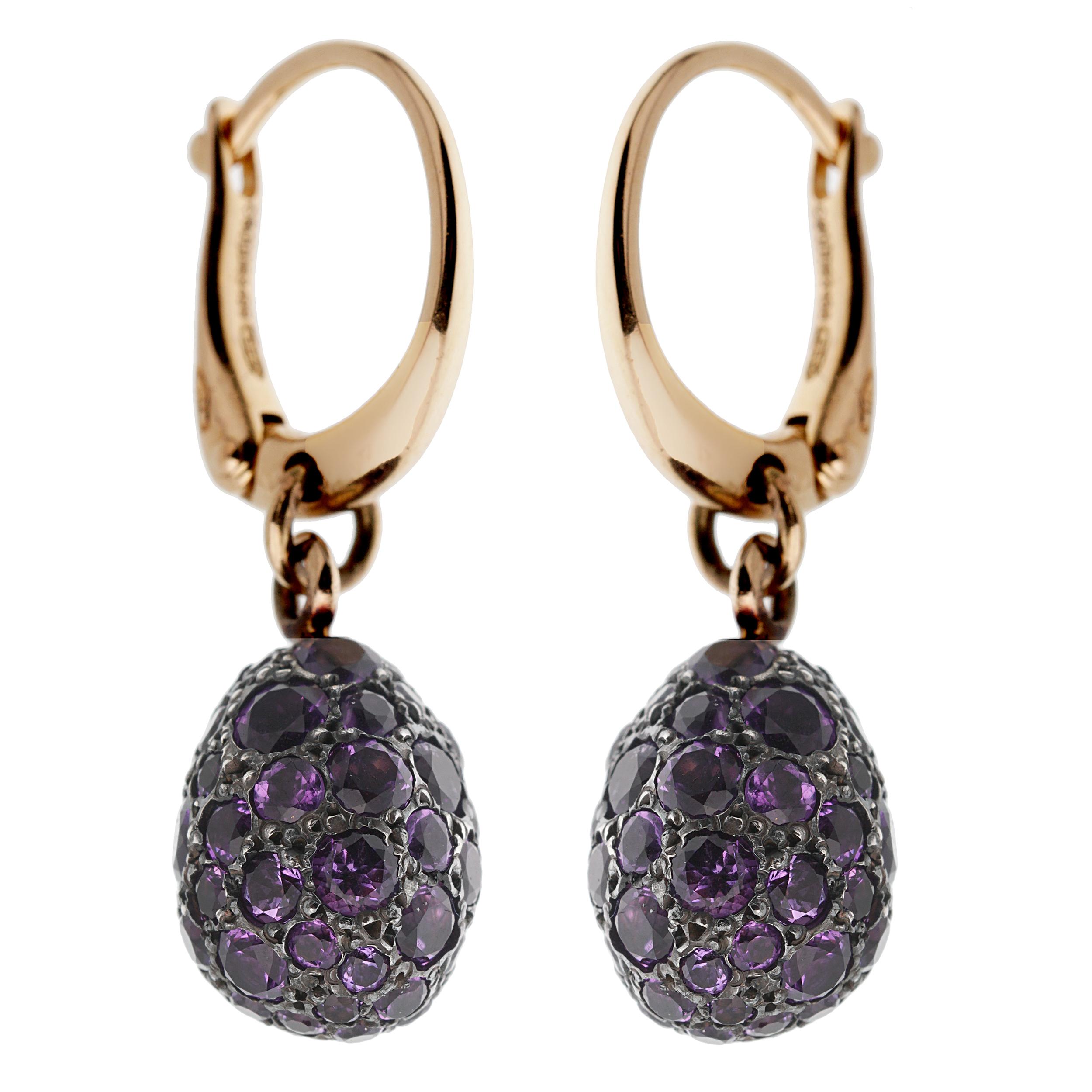 A fabulous pair of Pomellato earrings showcasing warm 18k rose gold with a blackened silver pendants adorned with pave set amethyst stones. The earrings have a total length of 1.20