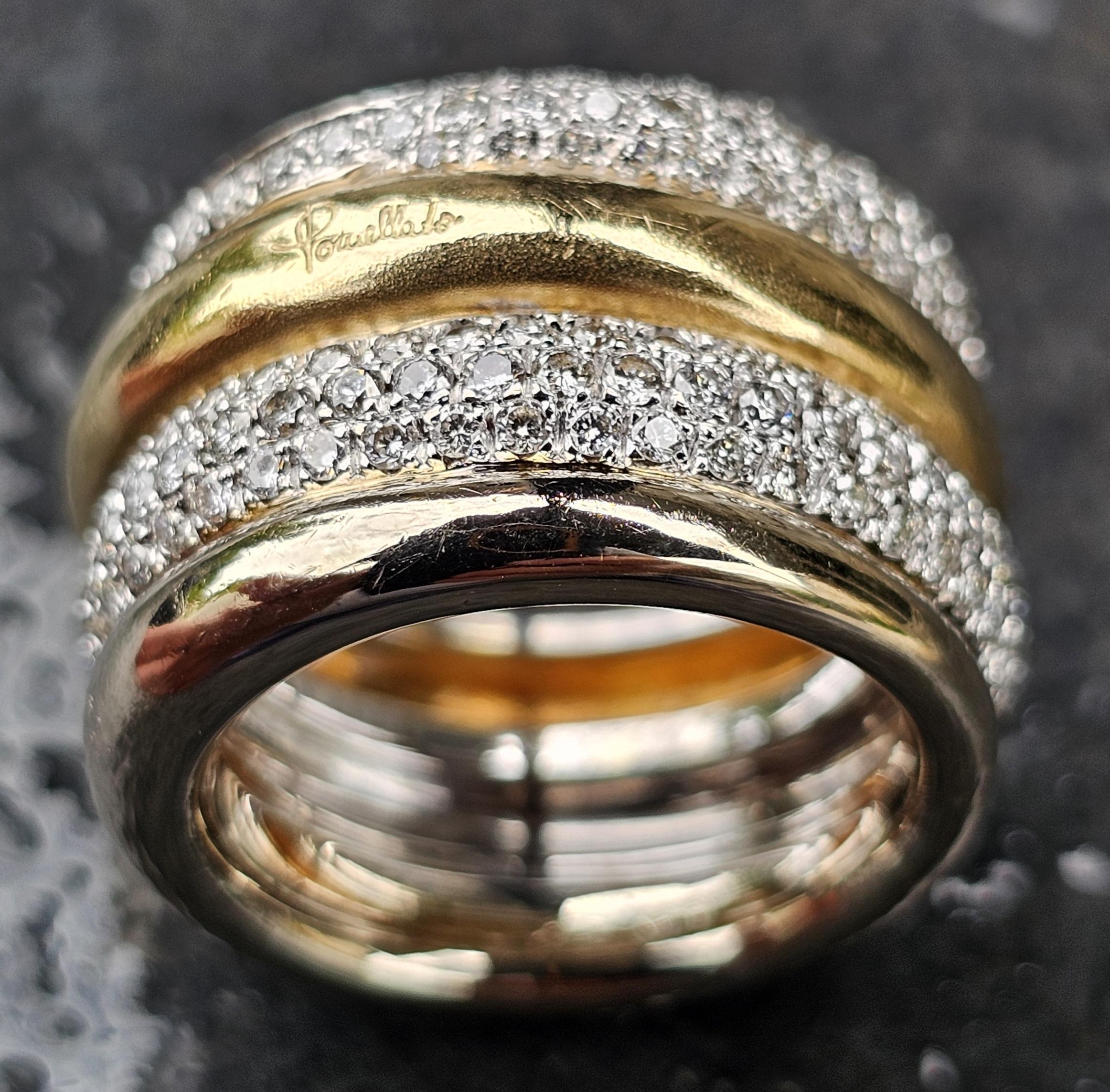Cette exquise bague est une création de Calle et s'appelle Tubolare. Réalisé en or blanc et jaune 18 carats, il présente un design luxueux avec une bande centrale en or poli flanquée de deux rangées de diamants blancs ronds. Les diamants, qui