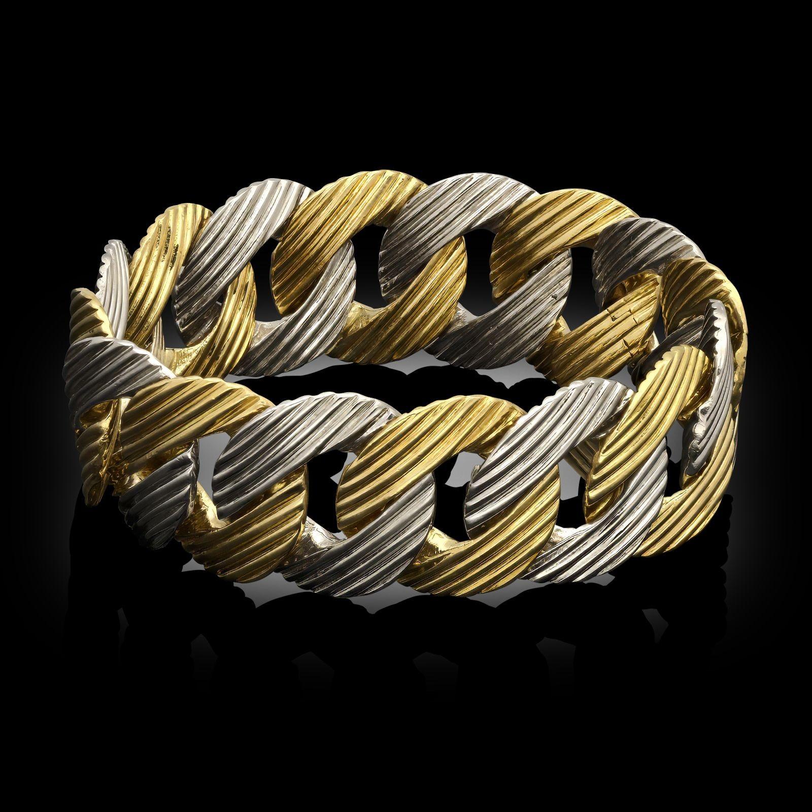 Vintage 18ct gold link bracelet, circa 1980. The bracelet is designed as a series of uniform links with a convex profile and striped engraved pattern, alternating between white and yellow 18ct gold and to a concealed
