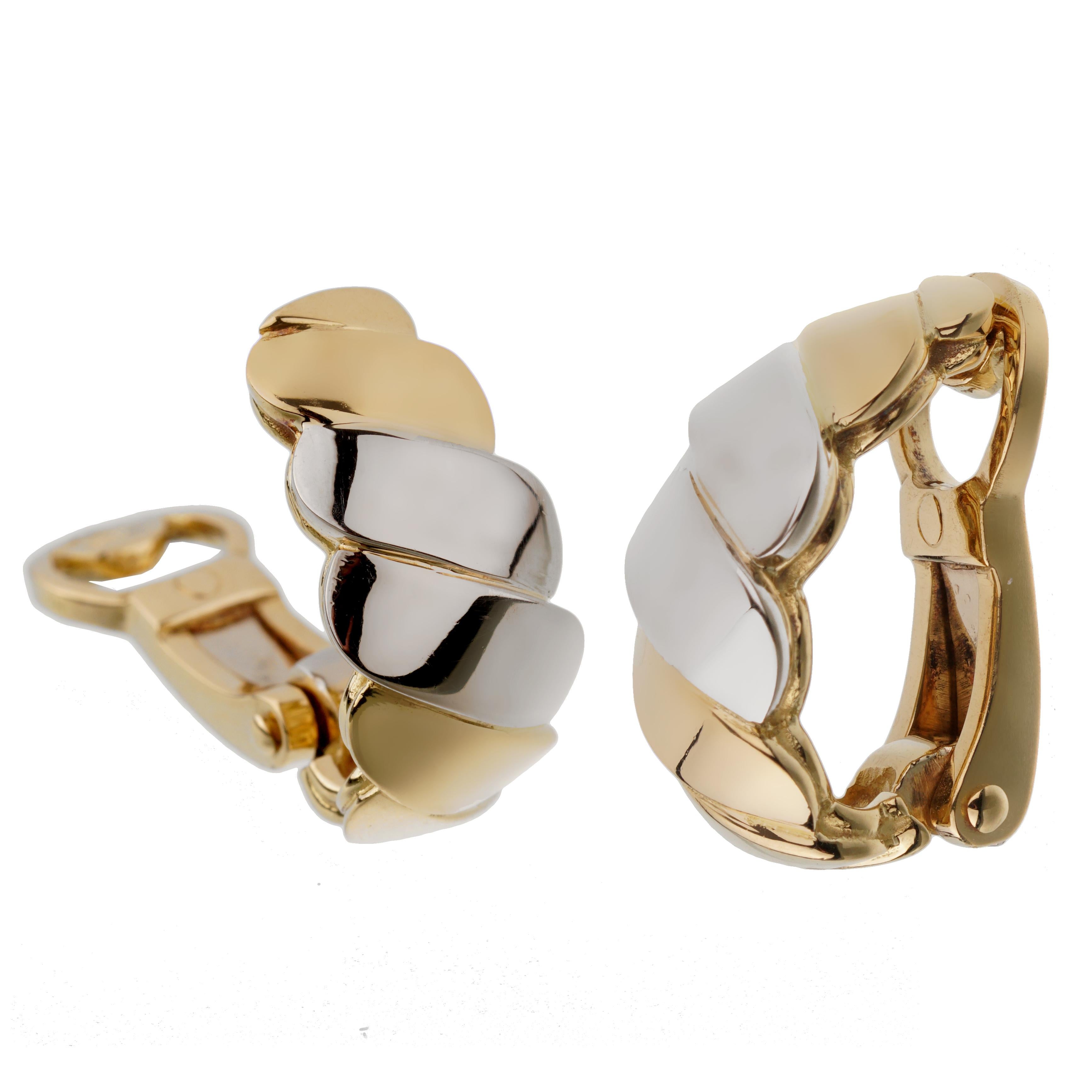 A rare set of Pomellato gold earrings showcasing a wave motif design in both 18k white and yellow golds. The earrings measure .74