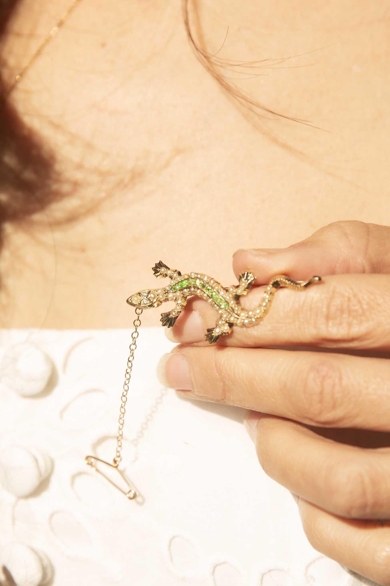 Crafted in 15ct carat gold, our Pomina Brooch is an antique treasure. An audacious salamander in motion - embellished with lush creamy seed pearls and bright green demantoid garnets that follow her spine. Curious and collectable she will be a