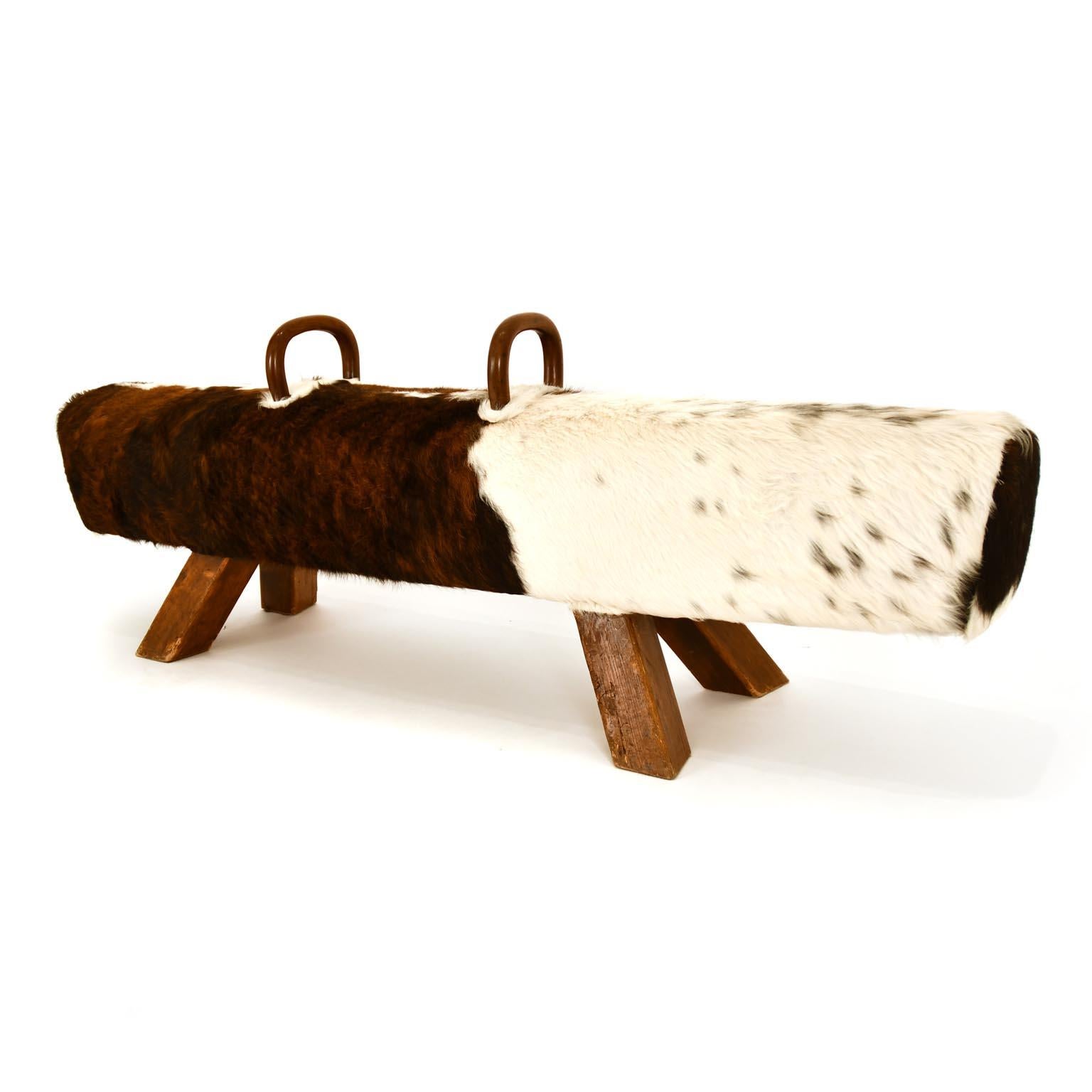 Amazing vintage Pommel horse made 1930s. Very decorative bench with a new cowhide upholstery. Your are able to remove the wooden handles with a metal crandle on the bottom. We deal with gymnastic equipment’s for many years, but this asymmetrical