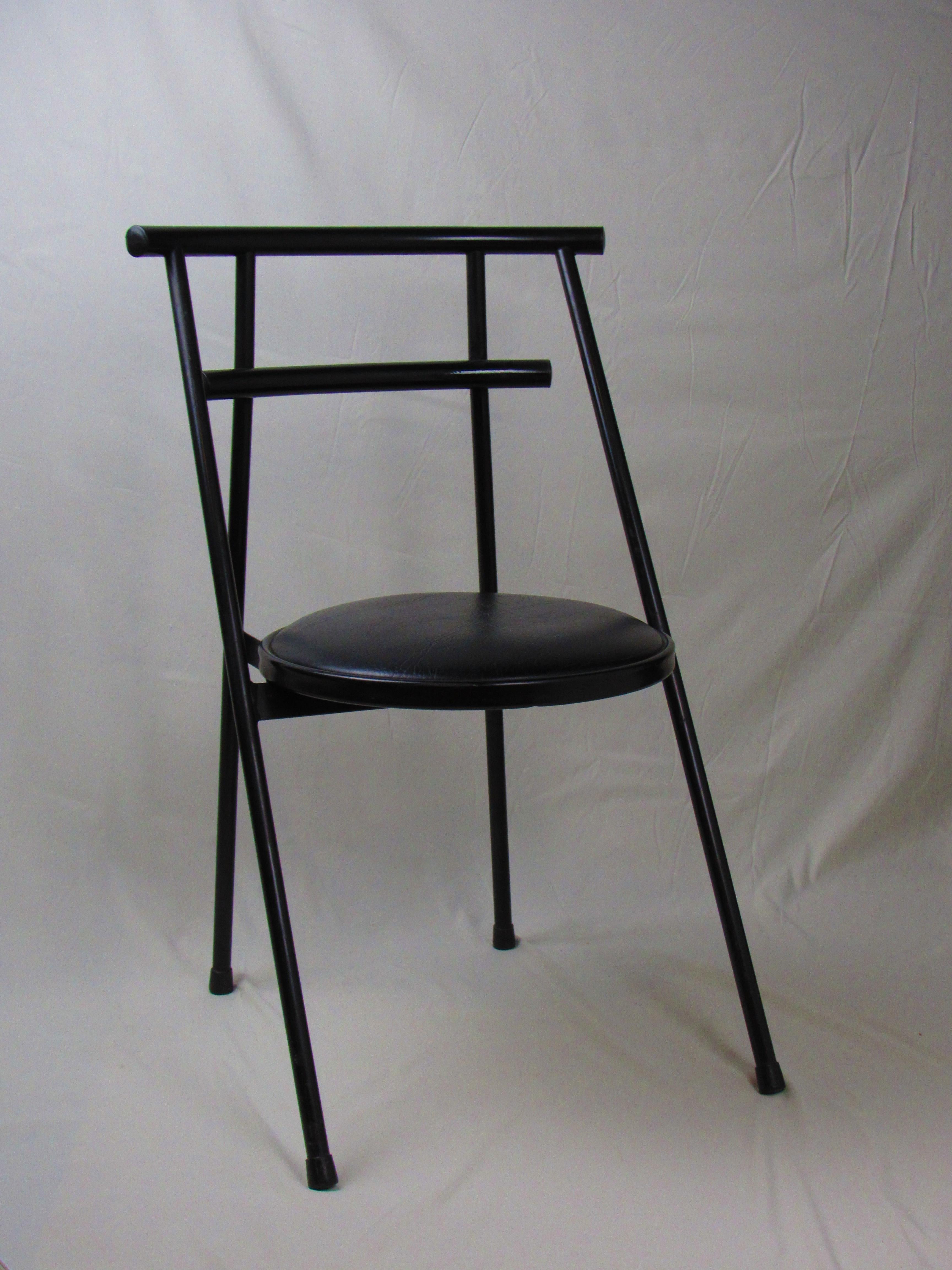 This striking postmodern tubular chair is a true statement piece, showcasing the bold, geometric lines and unique aesthetic that defines the PoMo design era. The chair features a sleek black metal frame with tubular construction, giving it a