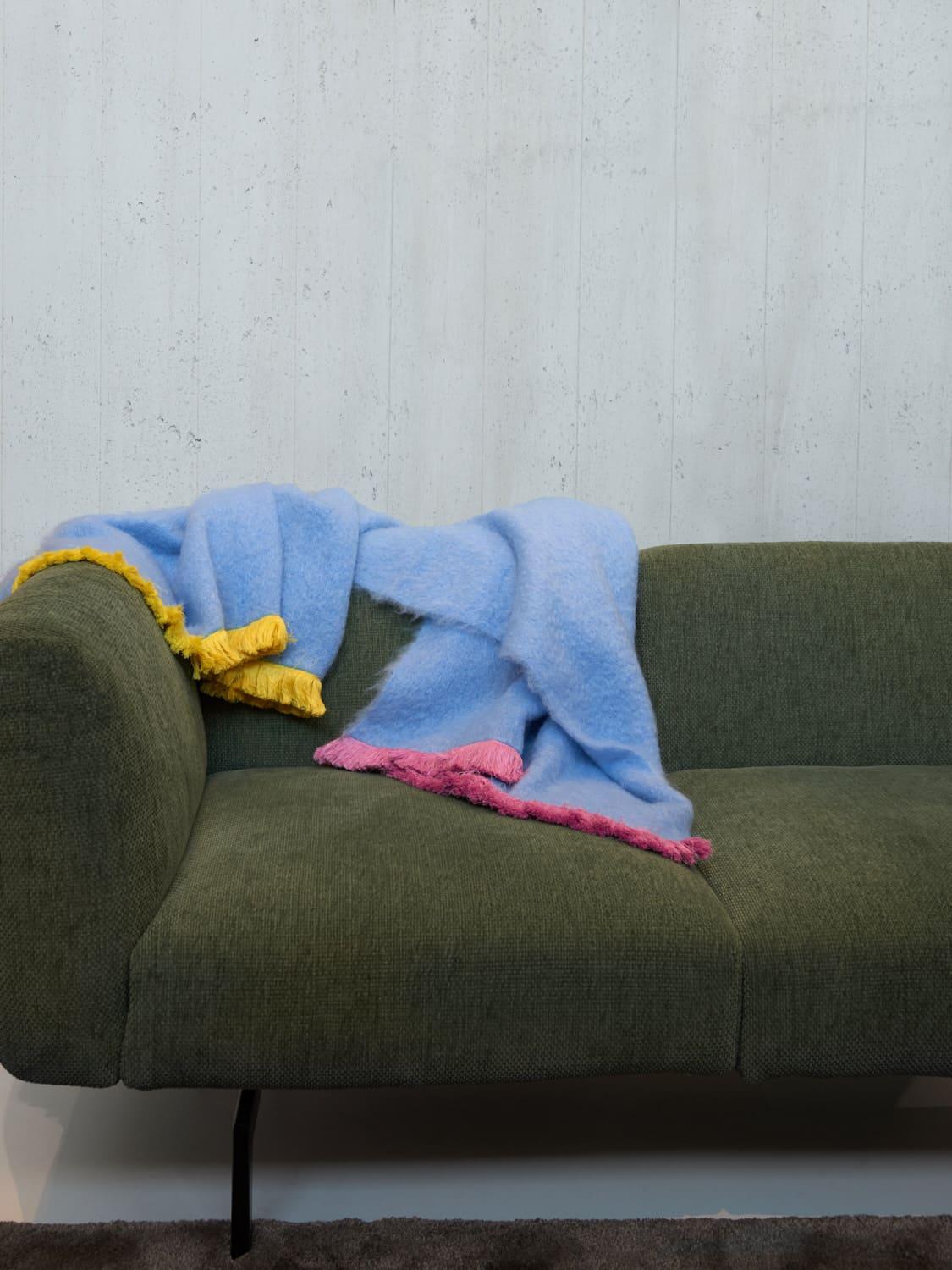 Pompallier, a sweet blue throw blanket made of the finest New Zealand mohair. Characterized with a pink and yellow fringe border completely embroidered by hand. Nothing as personal as your own interior, the colors can be customized on