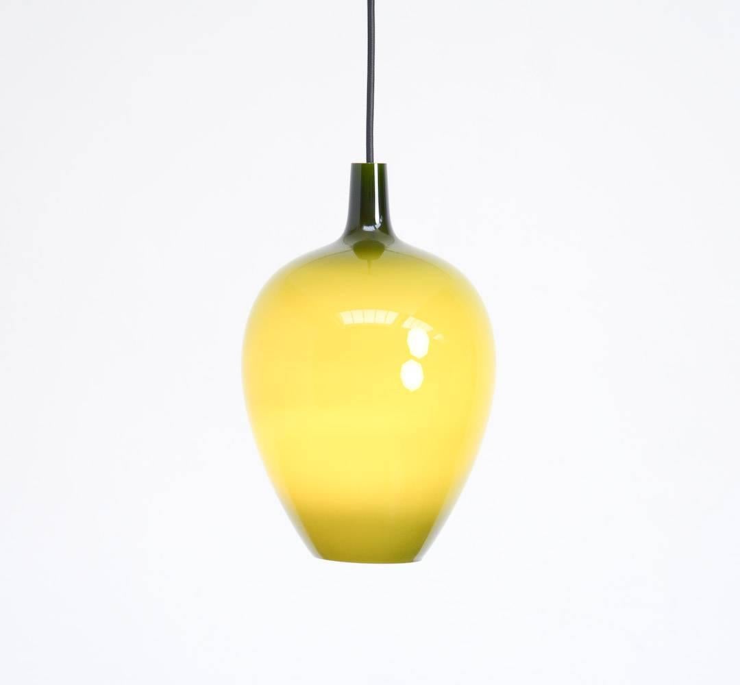 The Pompei pendant lamp was designed by Jo Hammerborg in 1963 for Fog & Mørup. Holmegaard, another Danish company, produced the glass for this lamp.
The classical inspired shape in mouth blown crystal glass is white on the inside and olive green on