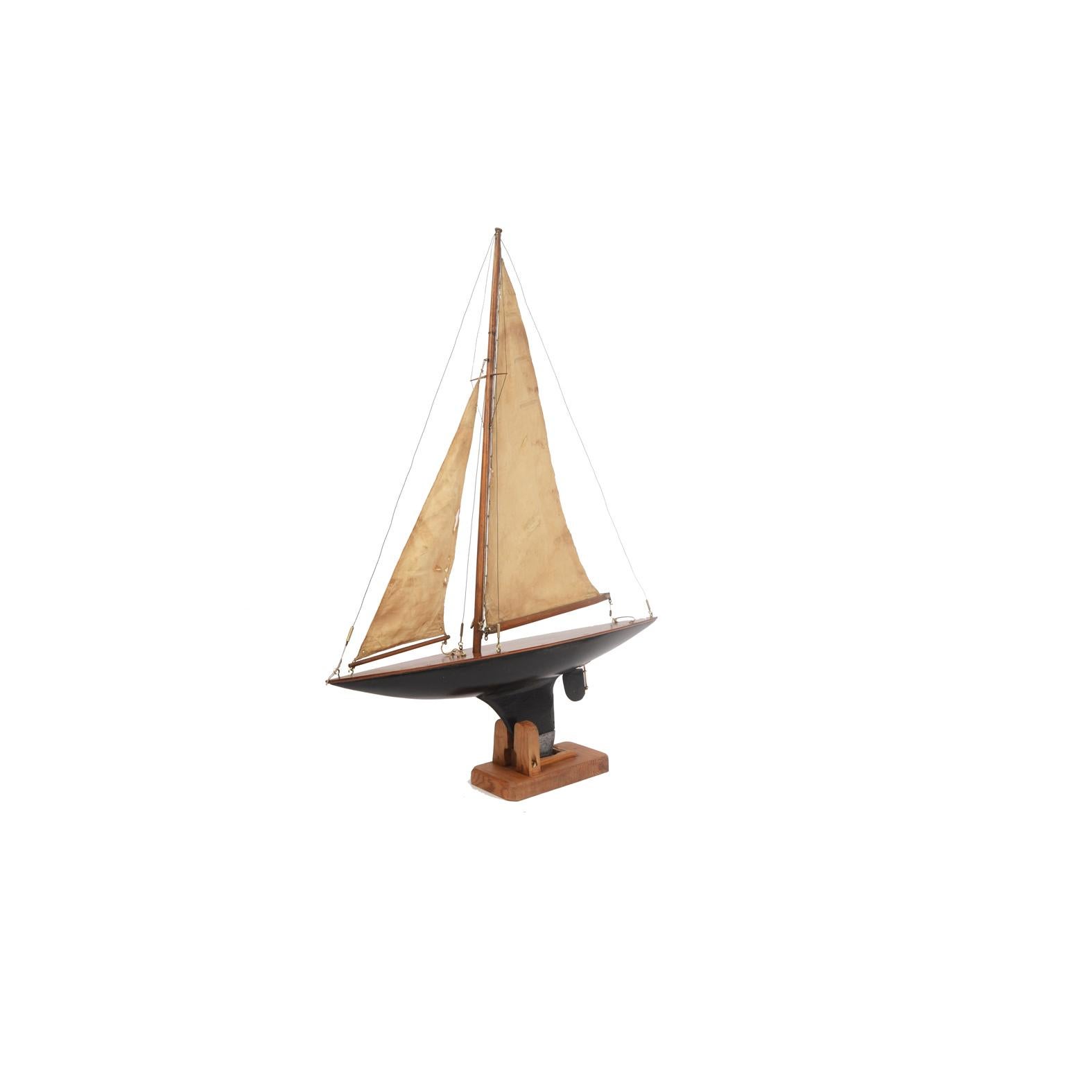 Pond model made in the early 1900s of a yacht used to navigate lakes. 
Original masts, rigging and sails, beautiful wooden hull with original paint, leaded keel and rudder, original custom made wooden support. 
Good condition, some tears in the
