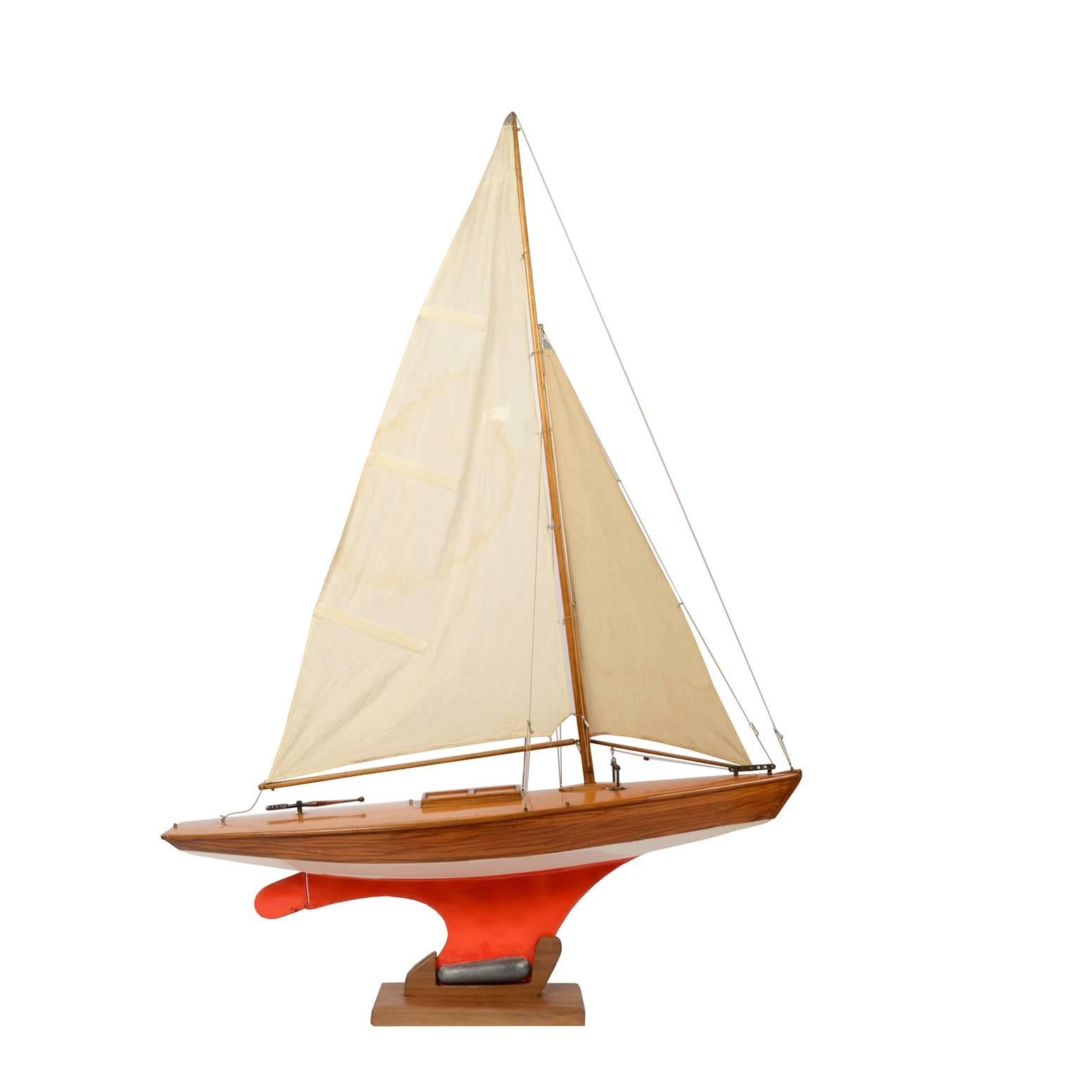 Pond Model on wooden base, red hull and lead ballast. This could be a model of yacht designed by the British naval architect Laurent Giles, made in the fifties of the last century. Very good condition. Measurements: 86 x 21 H 117.