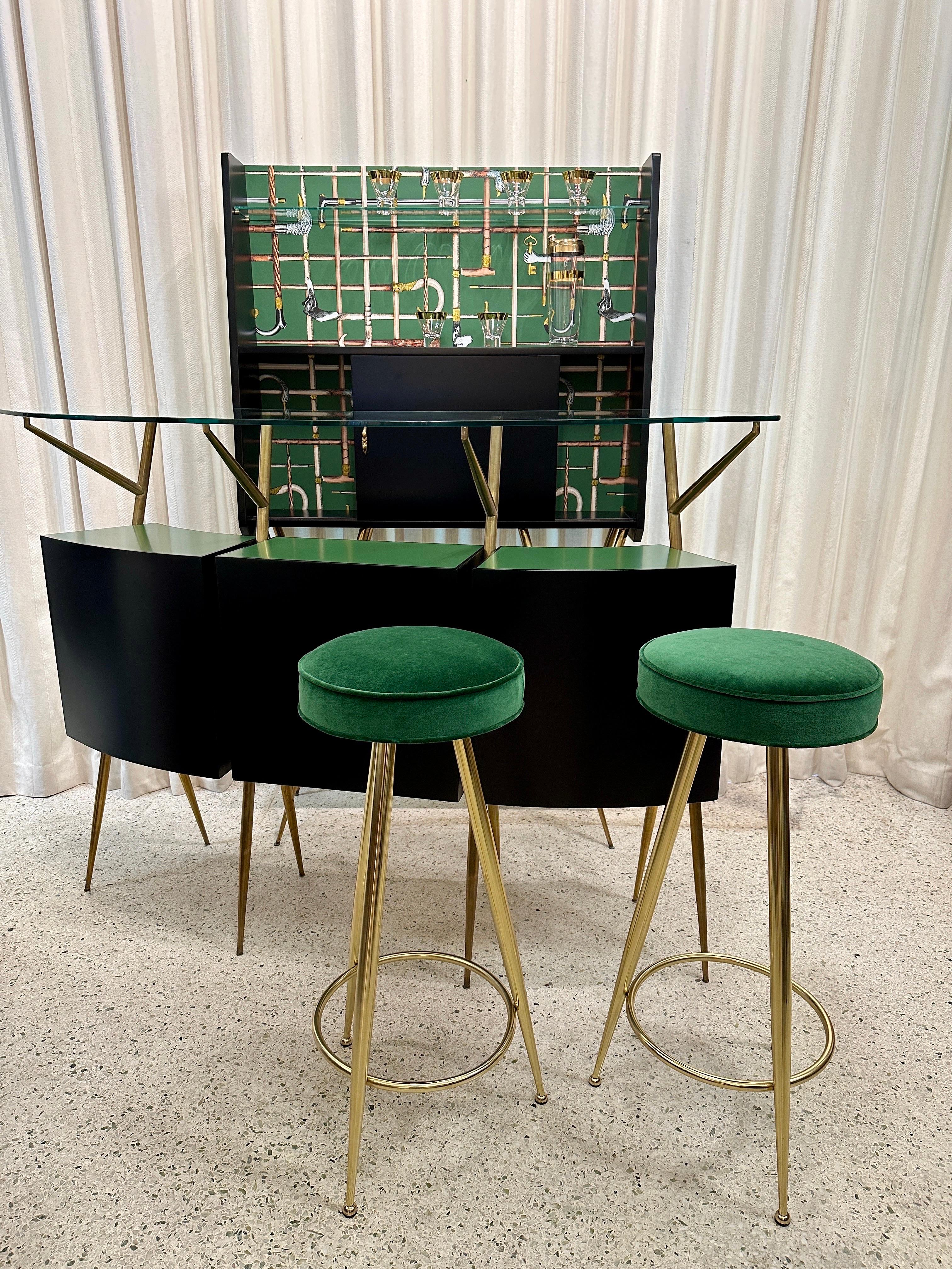 This wonderfully restored and updated Bar Set in the style of Gio Ponti boasts vivid and whimsical Fornasetti wallpaper adorning the back bar.  In solid matte black and brass hardware, legs and pulls, this set includes the main dry bar with open