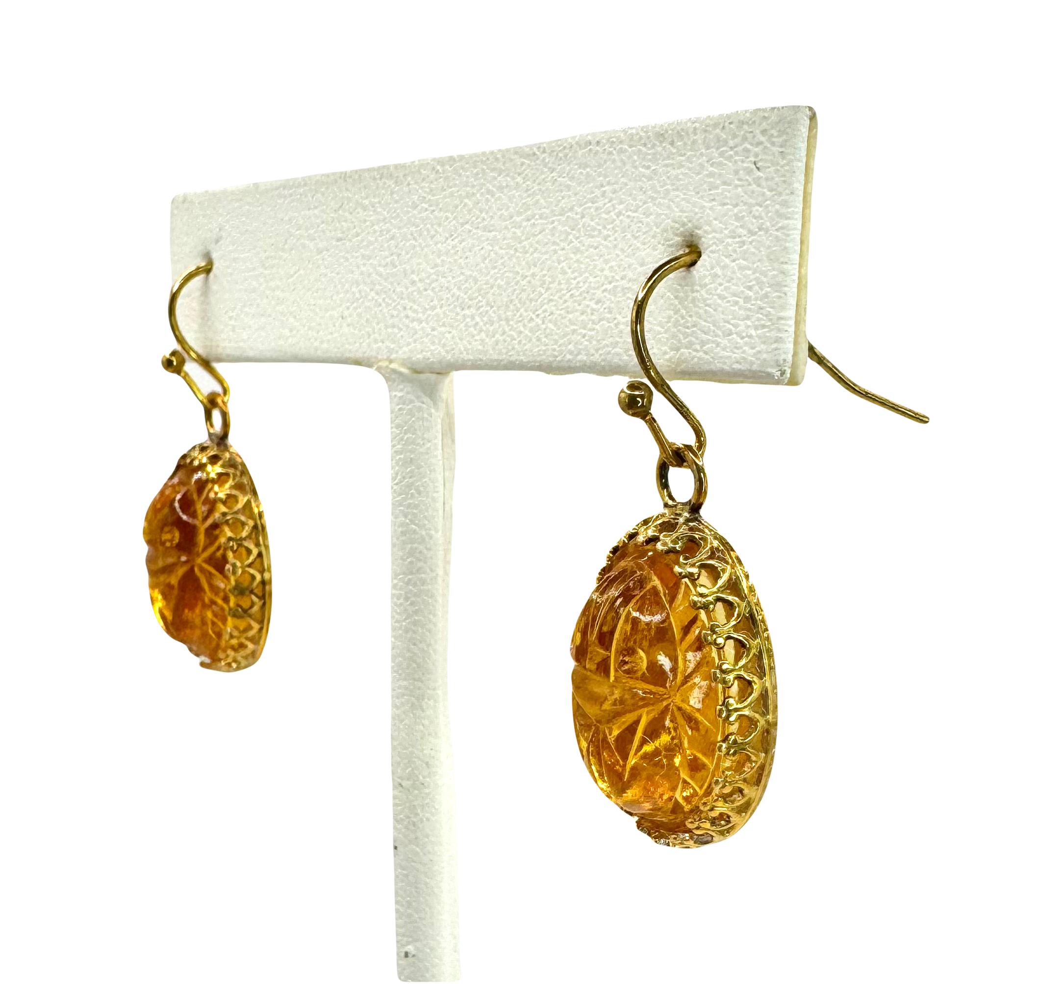 These Egyptian Revival glass scarab earrings are made from amber glass. The molded glass scarabs were made in Czech Republic. The glass was made to look like true amber.

The scarabs are set in a gold plated crown bezel and have gold-fill French ear