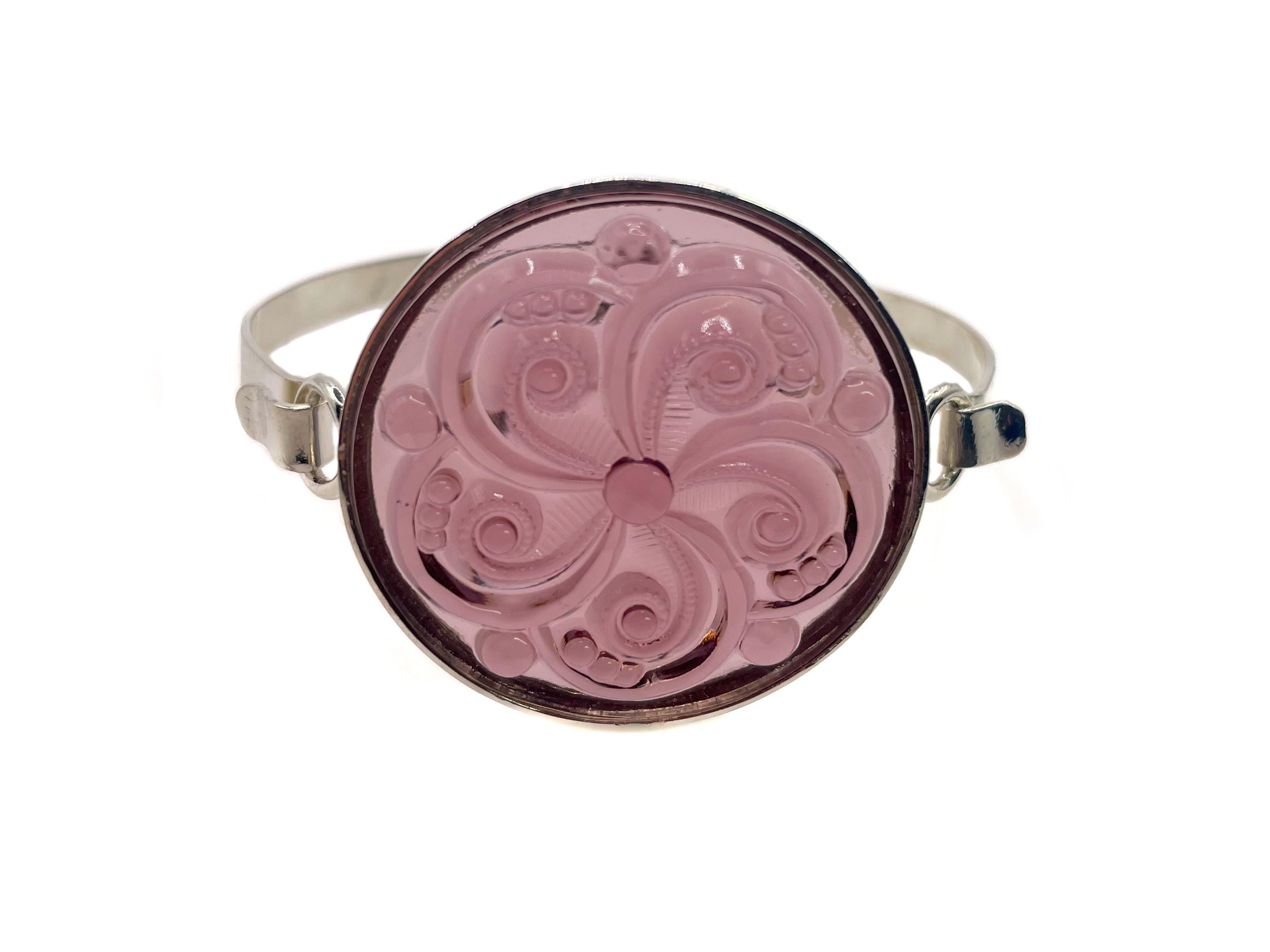This refined bracelet, in the style of Lalique, showcases a light amethyst swirl motif glass cabochon from Germany. 

The round molded piece of glass is set in a NEW sterling silver setting. It has an elegant and effortless hook clasp. The glass
