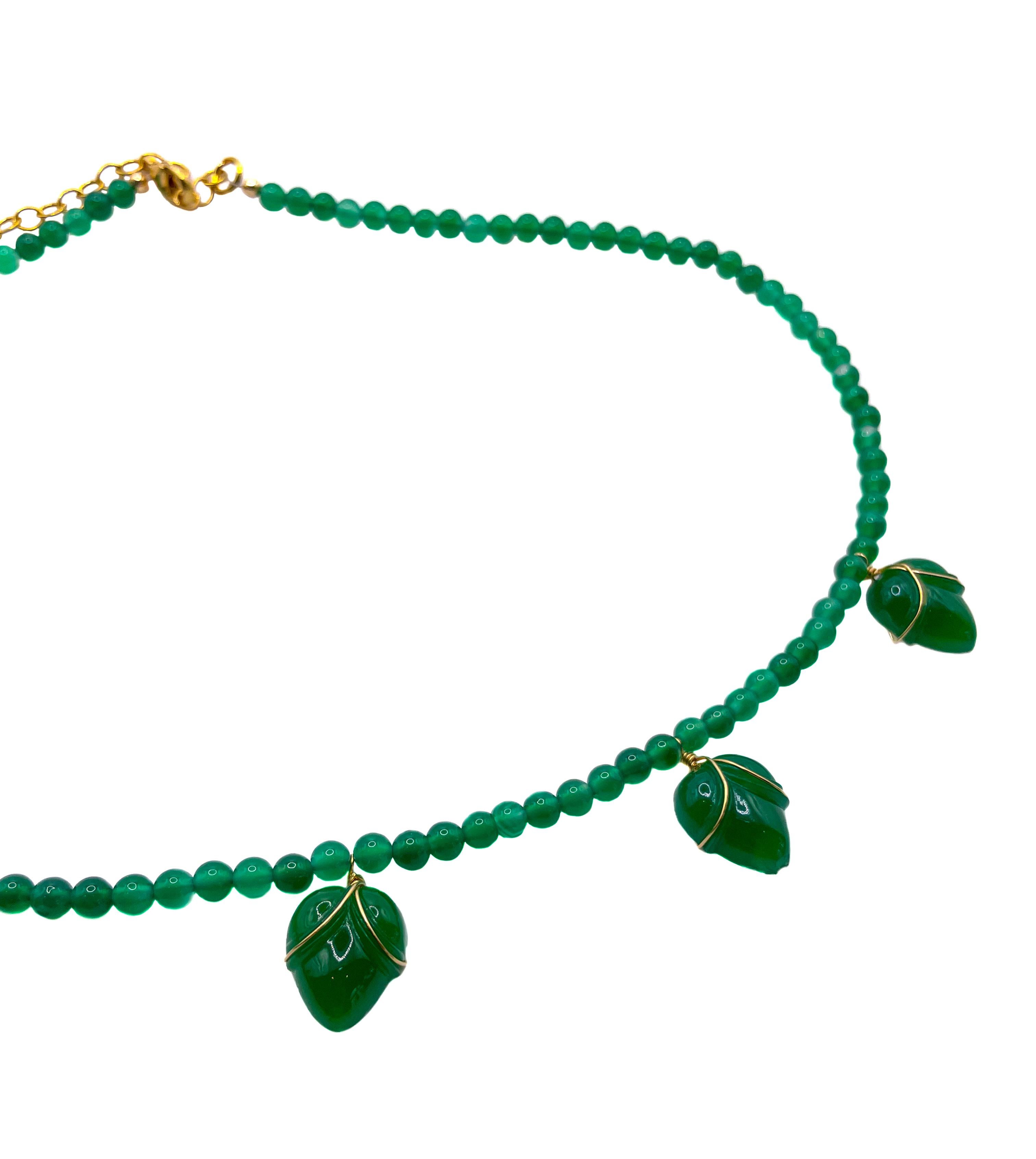 This one of a kind, striking emerald green beaded necklace displays five glass flower buds made from original vintage glass from 1950s Czech Republic. Each glass flower bud is individually wrapped with gold-filled wire and delicately separated by