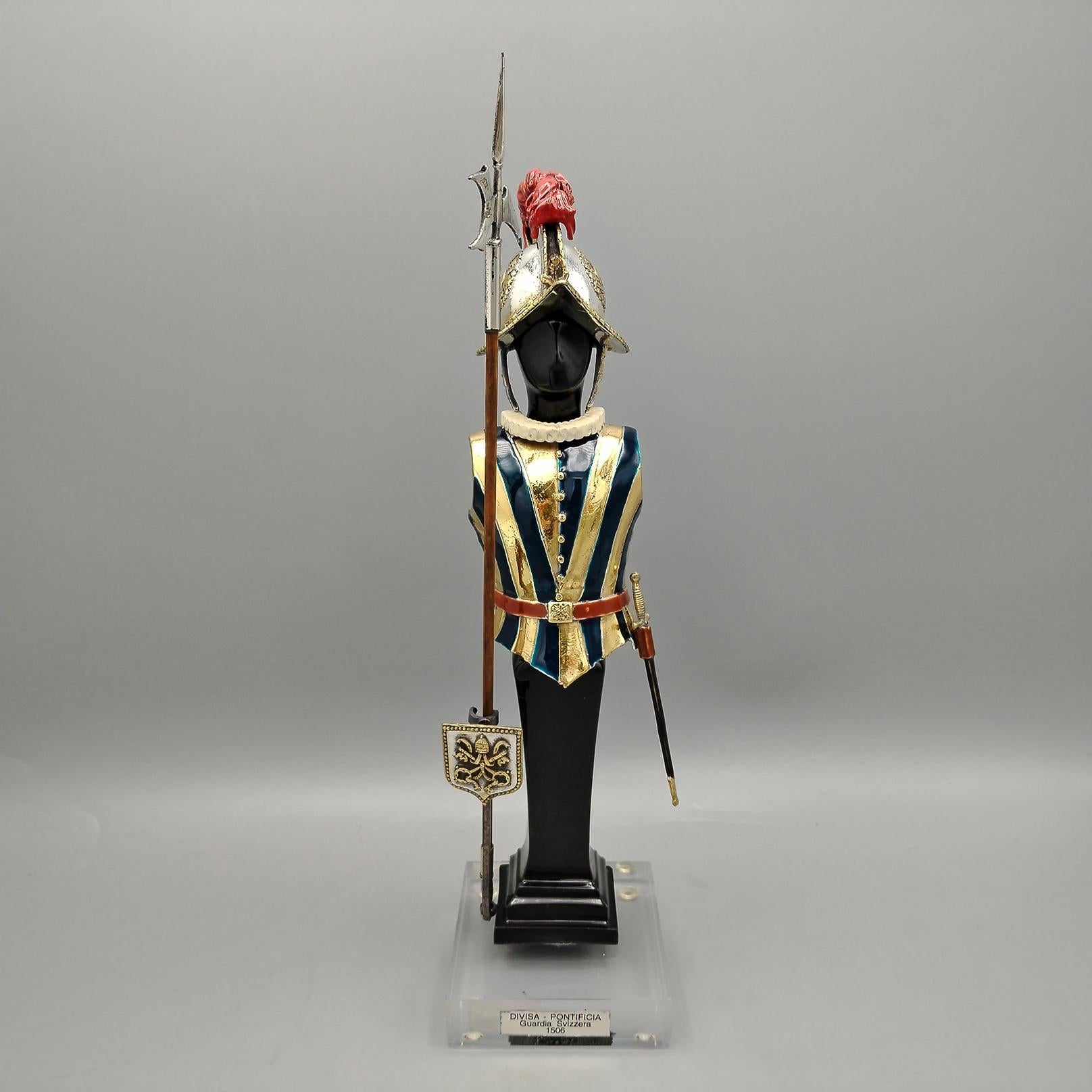 Pontifical Guard Uniform - Swiss Guard in Sterling silver with enamel and gold finish.
The base of the miniature is in plexiglass, while the body that supports the uniform is in black resin.
The uniform was made with the casting technique and