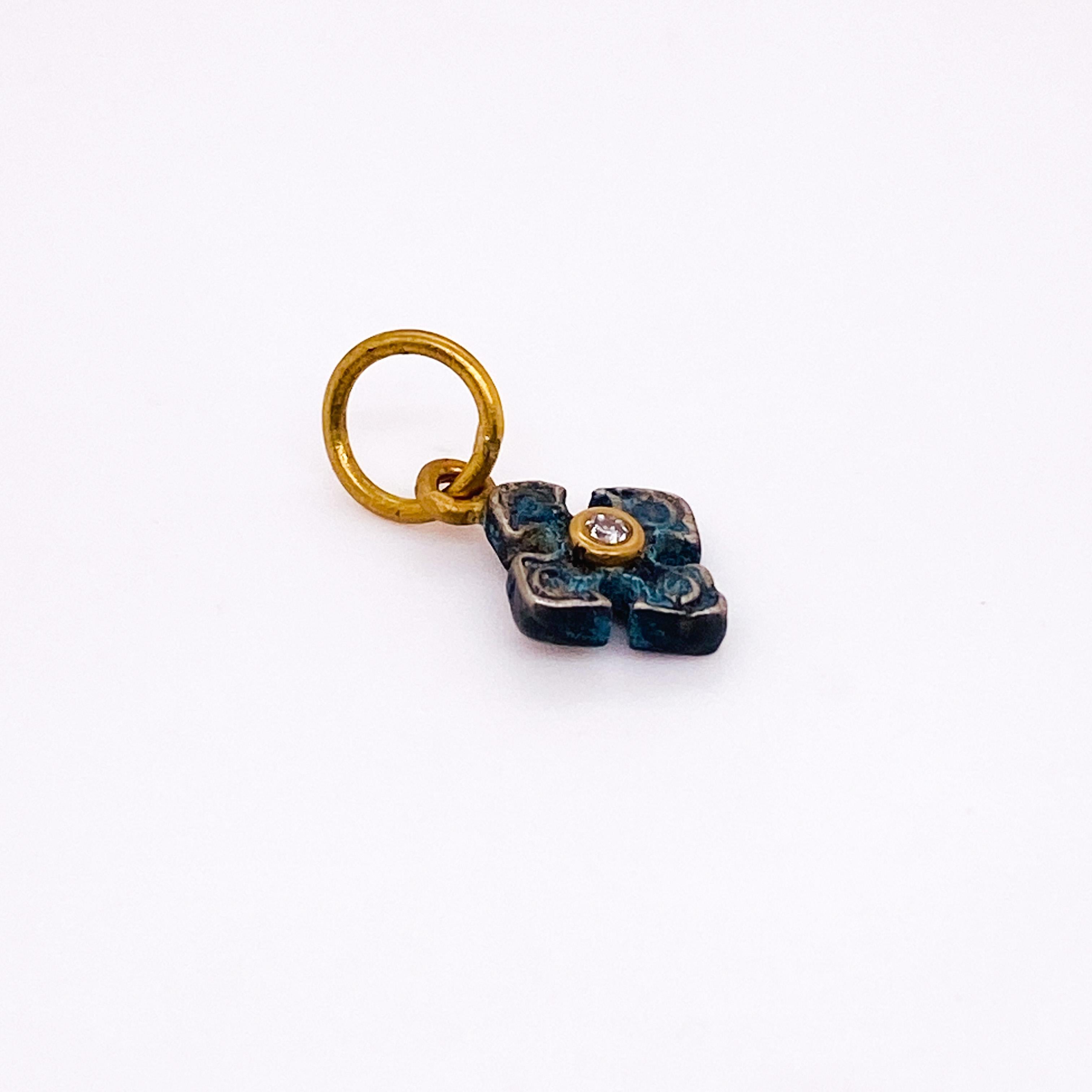 Take yourself back in time with this one-of-a-kind Pontus Greek cross charm. A classic round single cut diamond sits in the center of the antiqued sterling silver cross in a 24 karat yellow gold bezel. The top of the charm is suspended with 24 karat